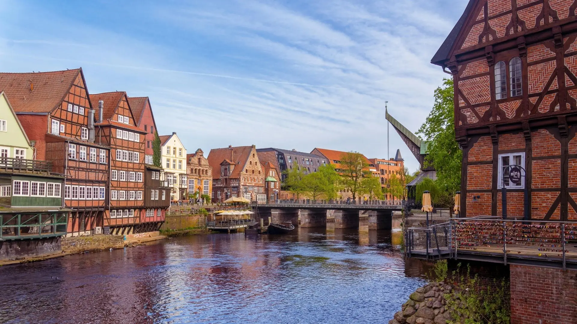 Historische Fachwerkhäuser entlang eines Flusses in Lüneburg bei klarem Himmel