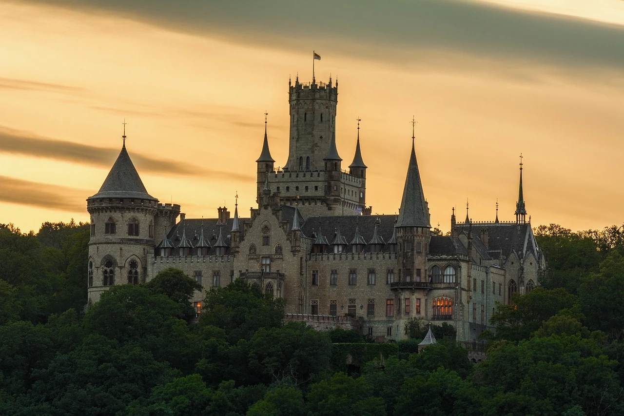 Das Schloss Marienburg bei Sonnenuntergang, majestätisch und eindrucksvoll, das perfekte Ambiente für die Geschichten von Maxton Hall.
