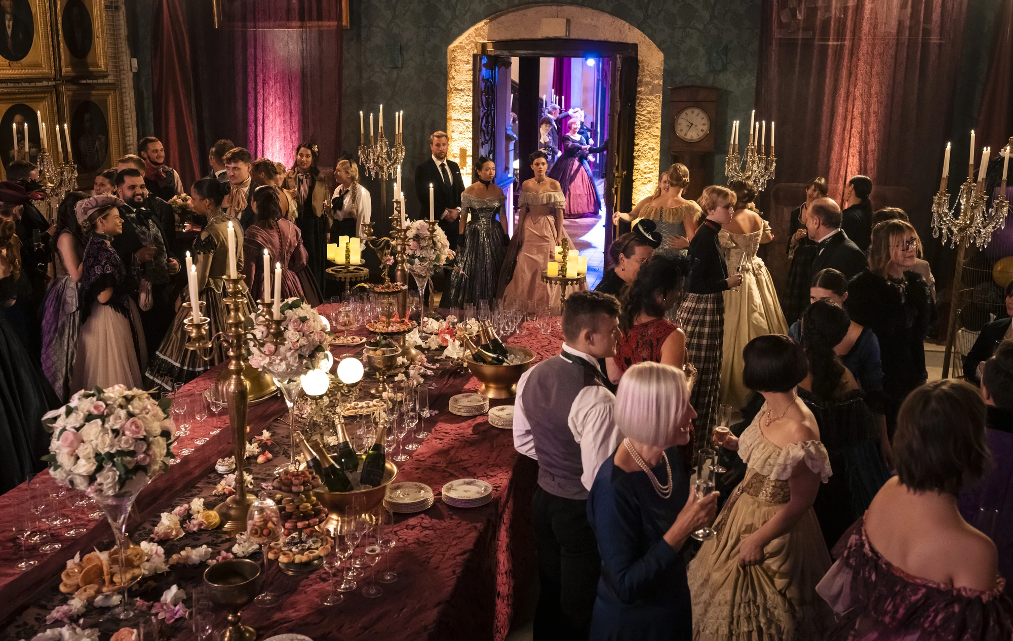 Maxton Hall Szenenbild - Ein Fest in der alle Charaktere elegant und gut gekleidet sind. Bunte und warme Farben erhellen die Szene.