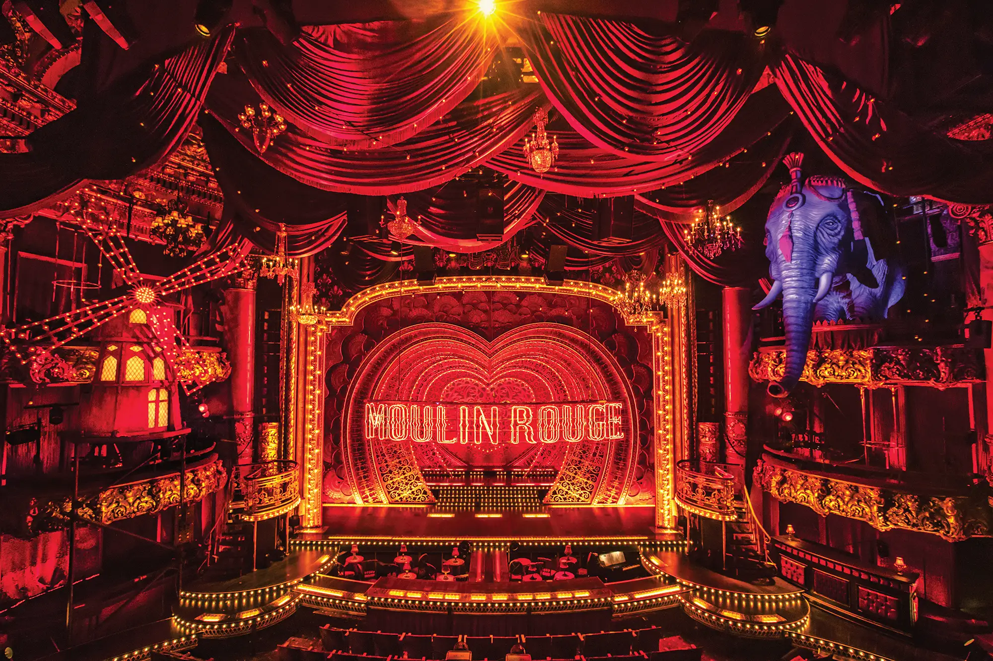 Moulin Rouge Köln - das Musical mit opulenter Bühne rot beleuchtet und samtenen Vorhängen