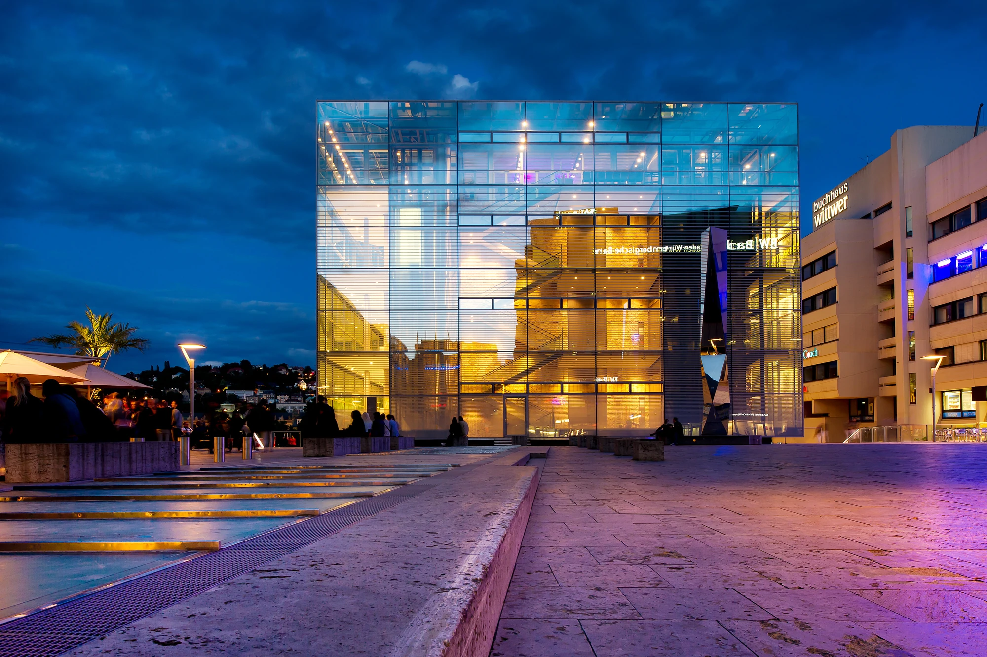 Außenansicht vom Kunstmuseum in Stuttgart - Großes beleuchtendes Gebäude aus Glas am Abend