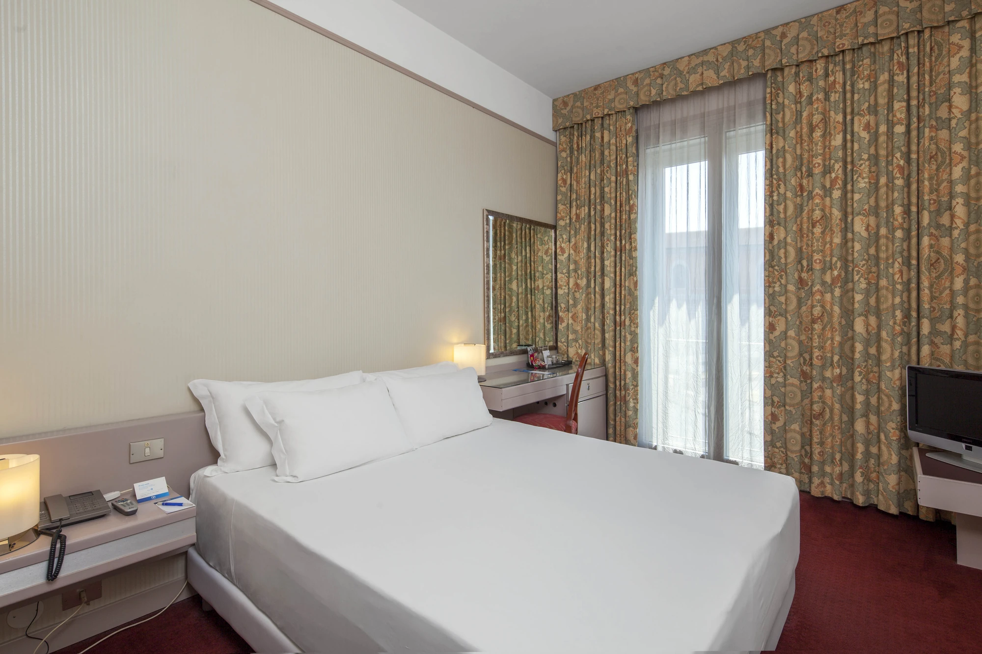 NH Pisa Hotel - Ansicht auf das weitere gemütliche Zimmer in neutralen Farben