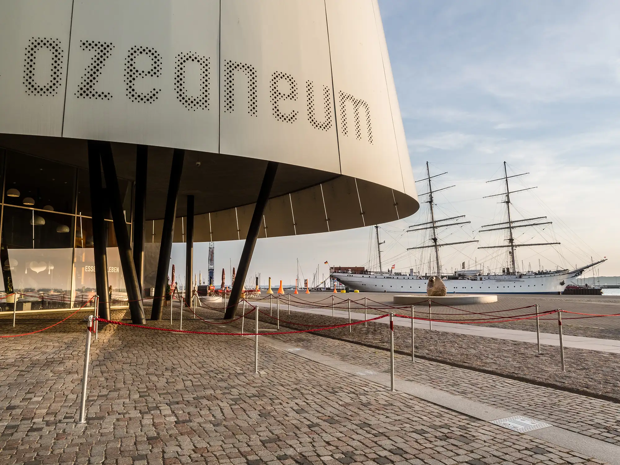 Ozeaneumsvorplatz und Gorch Fock bei Sonnenaufgang beim Aufenthalt mit Hotel Stralsund