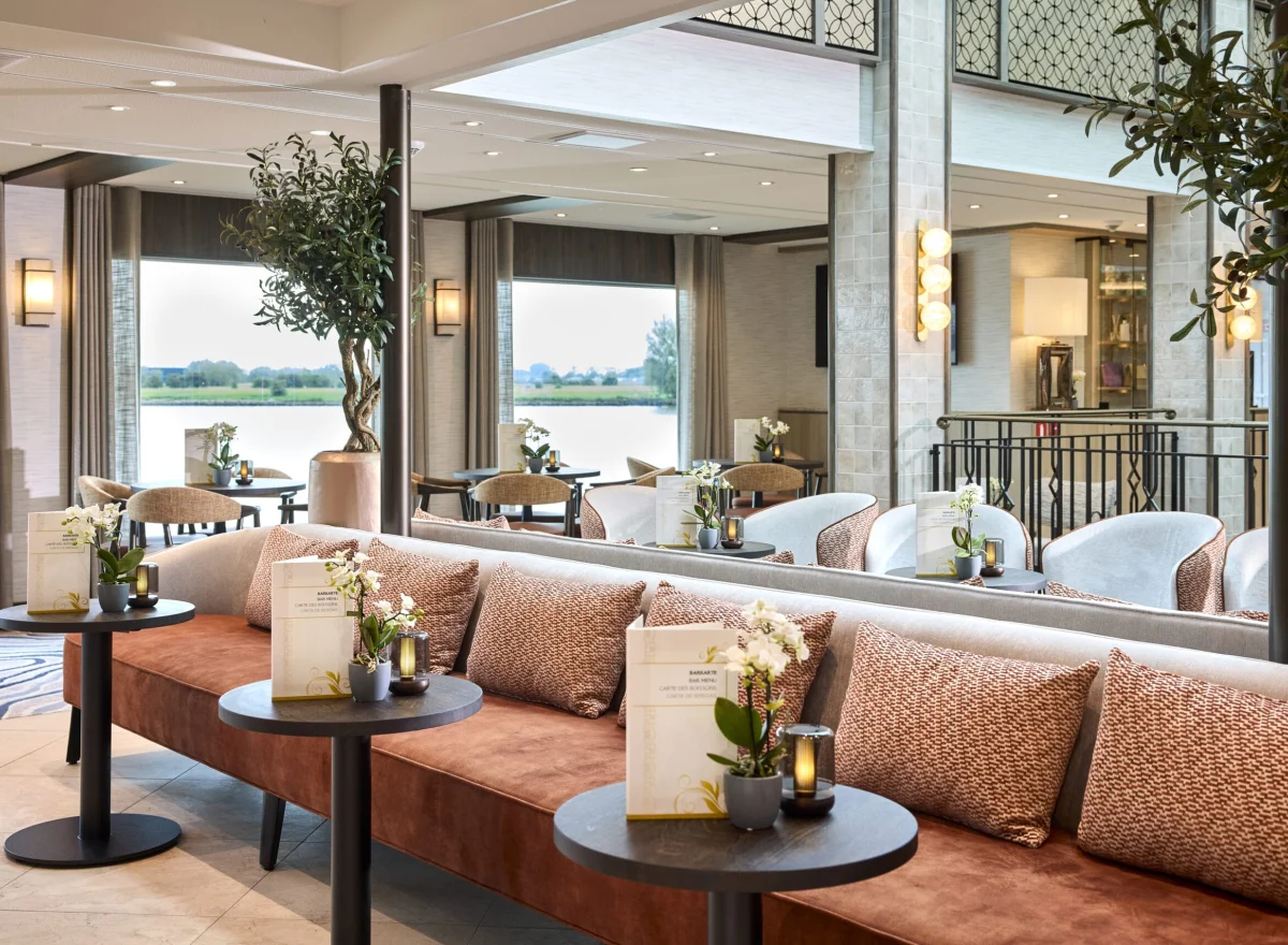Elegantes Café-Interieur mit gemütlichen Sitzplätzen und Blick auf den Fluss.