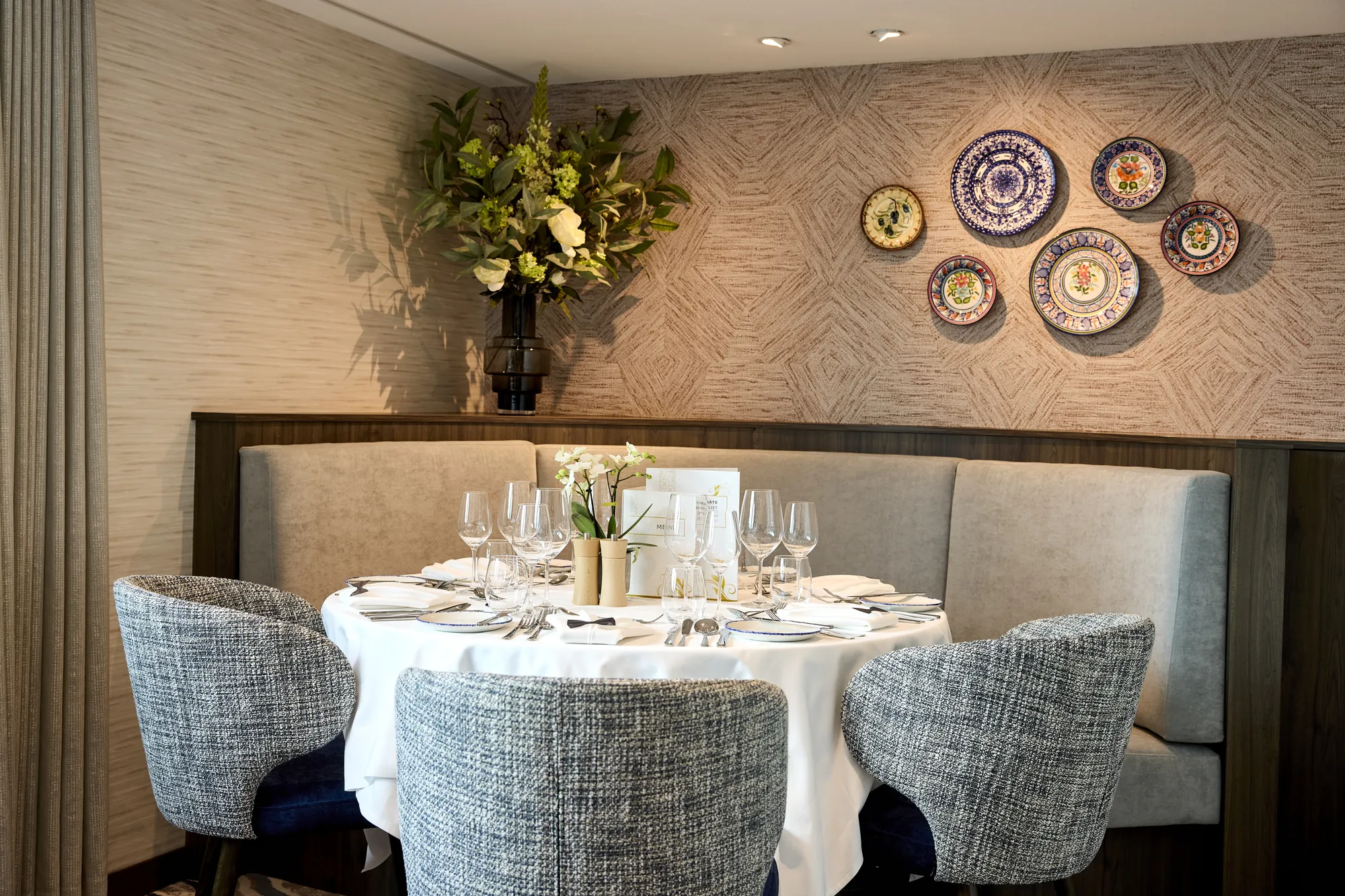 Eleganter Esstisch mit stilvollen Stühlen und dekorativen Tellern an der Wand.