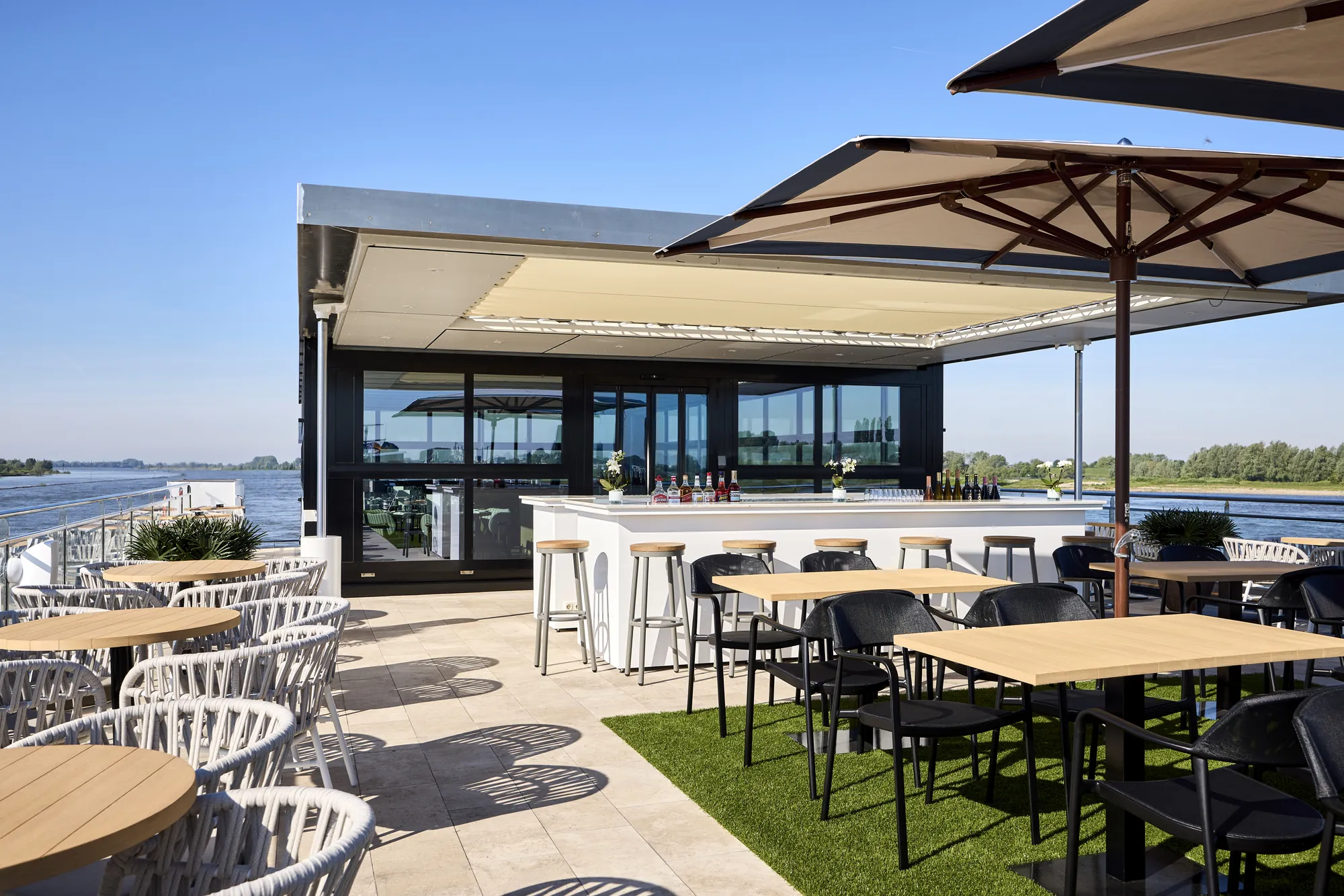 Moderne Terrasse mit Blick auf den Fluss und stilvollen Möbeln
