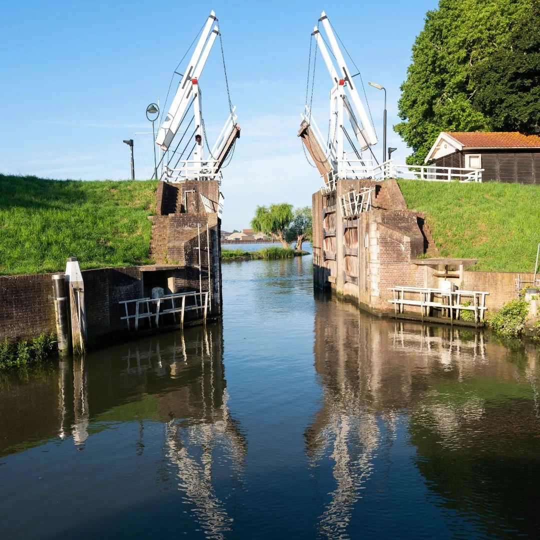 Ansicht einer Brücke mit Wasser und Bäumen im Hintergrund