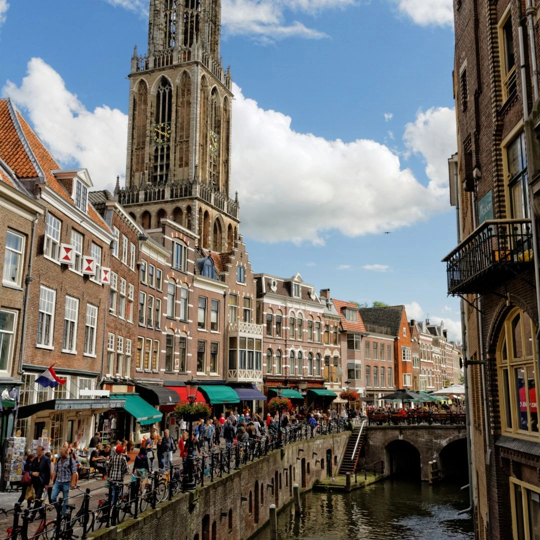 Blick auf das Stadtzentrum von Utrecht mit historischem Turm und Kanal.
