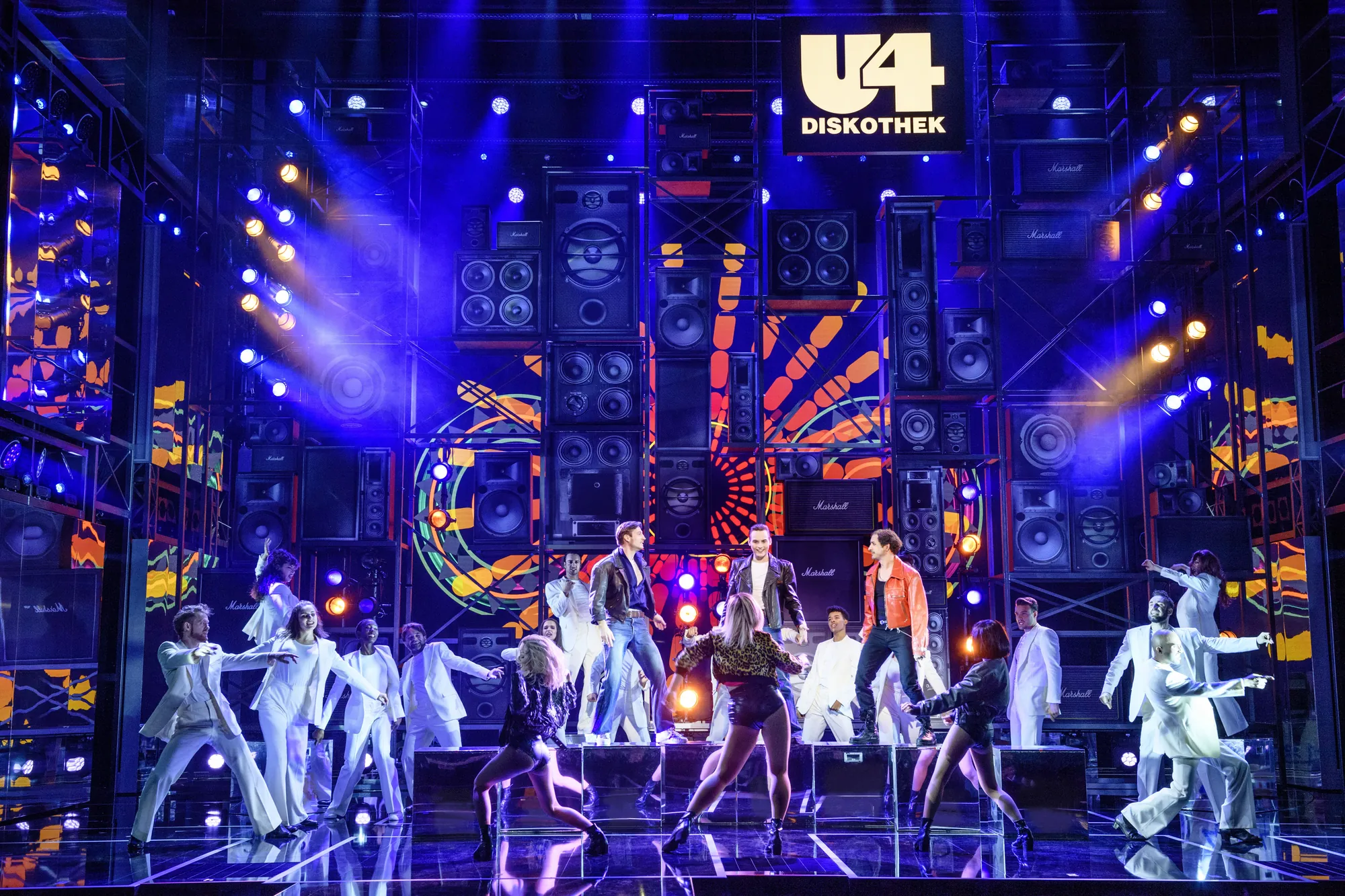 Rock Me Amadeus Musical - Falco auf der Bühne am Tanzen, umgeben von Menschen die tanzen