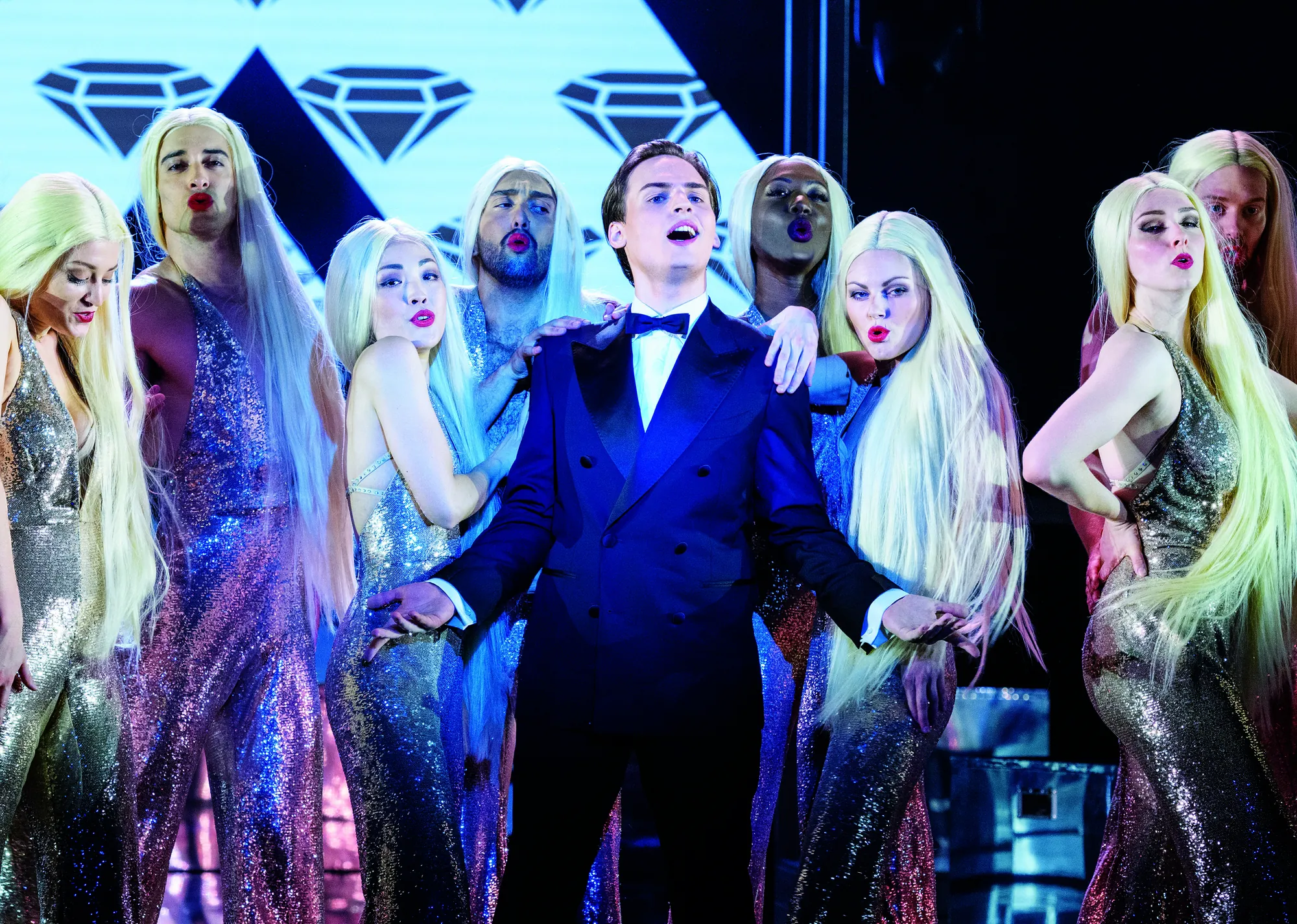 Rock Me Amadeus Musical - Falco umgeben von blonden Menschen in silbernem Kleid