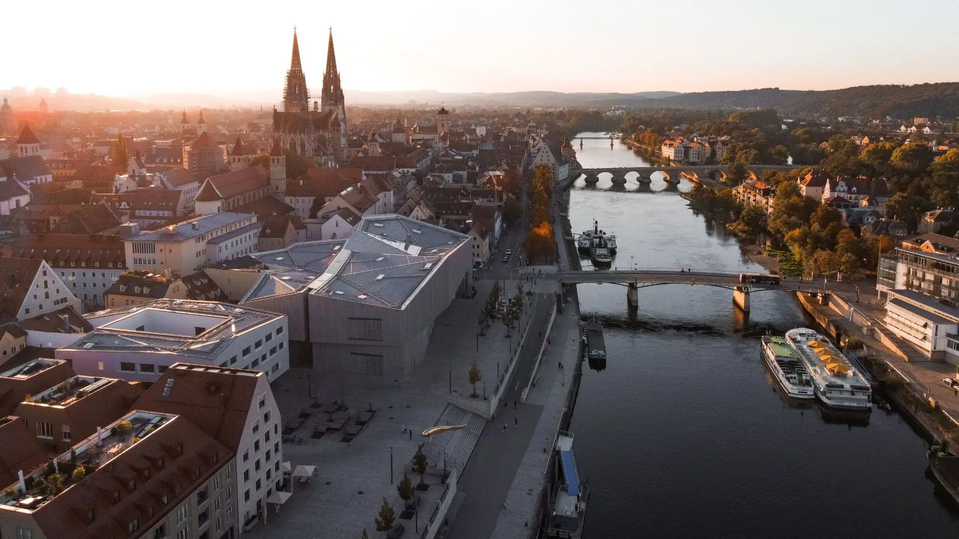 Panoramablick auf die Donau und die Altstadt von Regensburg bei Sonnenuntergang.