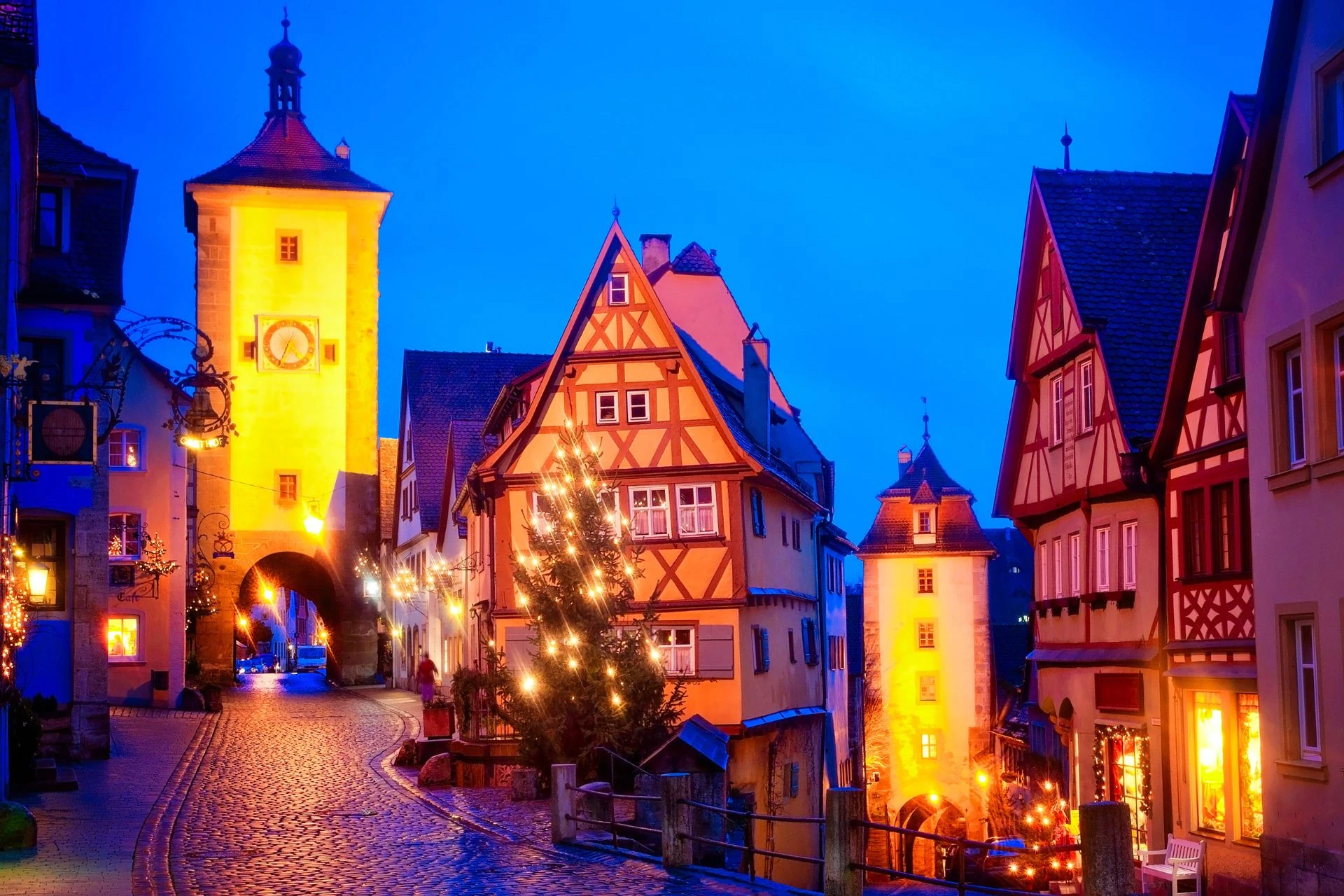 Bild der vorweihnachtlichen Innenstadt von Rothenburg ob der Tauber mit Fachwerkhäusern und Tannenbäumen.