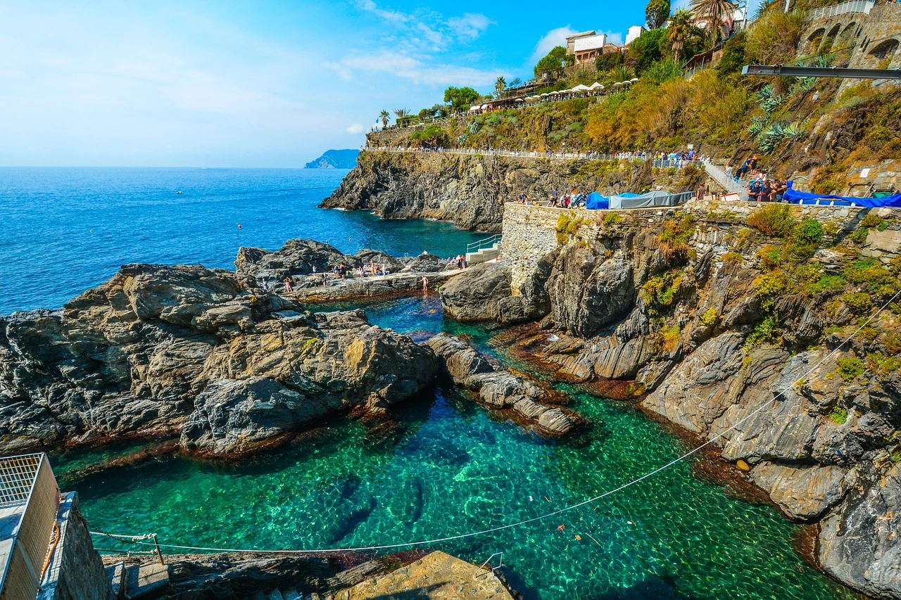 Poolbereich auf der schroffen, felsigen Küste von Manarola, italienische Stadt an der ligurischen Küste, von der Cinque Terre
