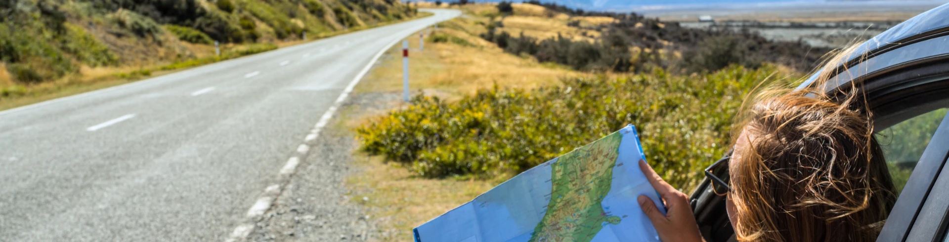 Reisende betrachtet eine Karte mit schöner Landschaft im Hintergrund.