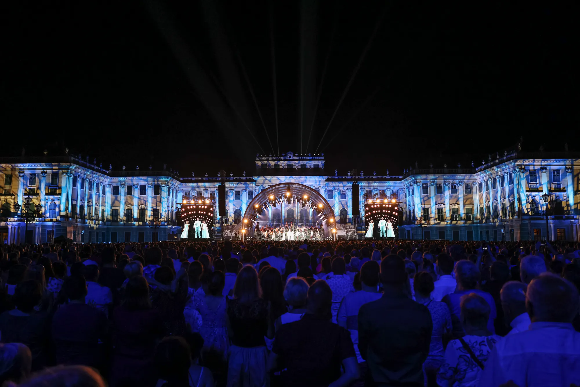 Elisabeth das Musical Konzert bei Nacht in angenehmer Atmosphäre - großes Publikum vor beleuchteter Bühne, majestätisches Schloss Schönbrunn im Hintergrund