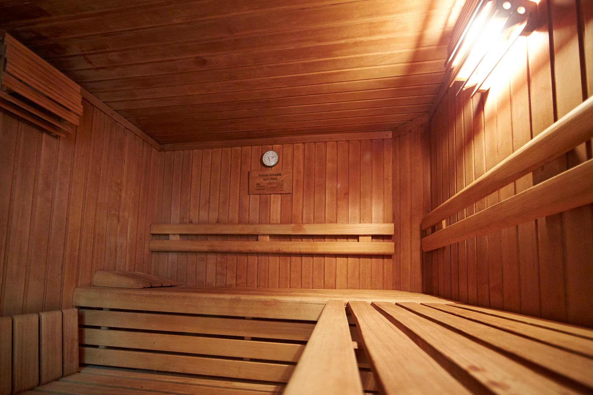 Gemütliche Holzsauna mit warmem Licht und Holzverkleidung.