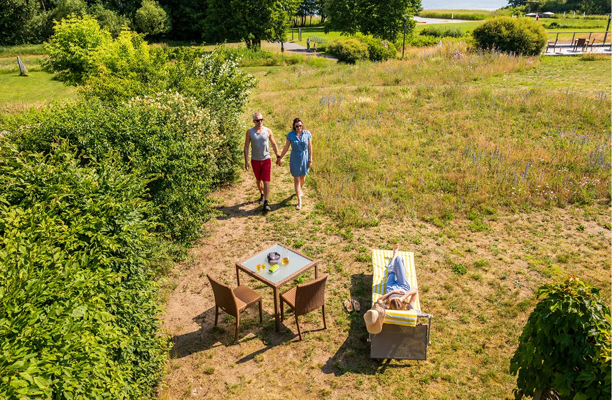 Familie geht über Terrasse im Schilfdort
