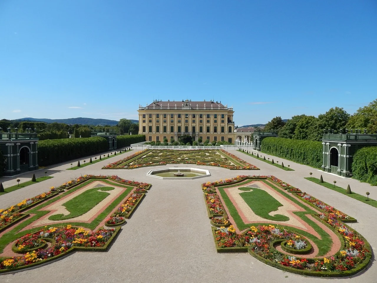 Frontansicht des Schlosses Schönbrunn in Wien, umgeben von prachtvollen Gärten.