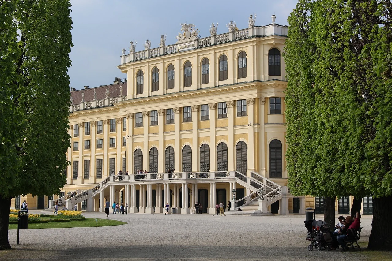 Schloss Schönbrunn von der Parkseite aus gesehen, mit gepflegten Gärten im Vordergrund.