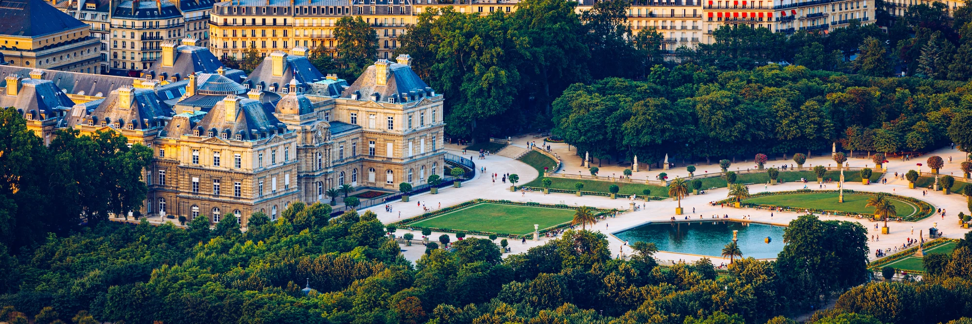 Panoramablick über den Jardin du Luxembourg, der mit klassizistischer französischer Gartenkunst, farbenfrohen Blumenbeeten und einladenden Terrassen geschmückt ist.