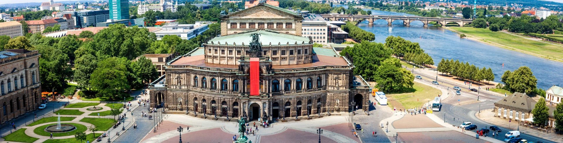 Historisches Gebäude der Semperoper in Dresden mit Elbe und Brücken im Hintergrund