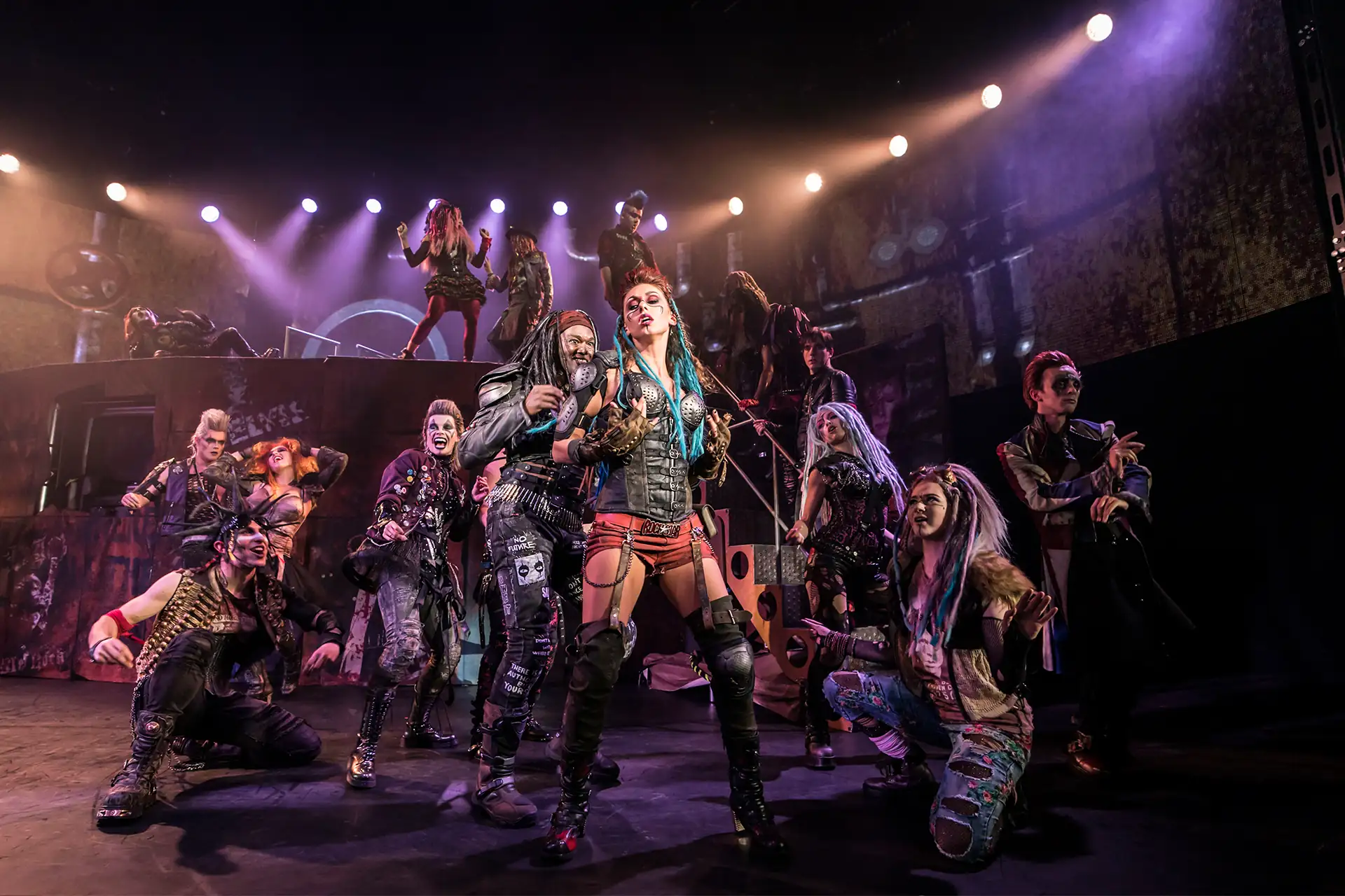 We will Rock You – Das Musical. Szenenbild: Ensemble bei einer Tanzchoreografie in rockigen Kostümen. (UK Cast)