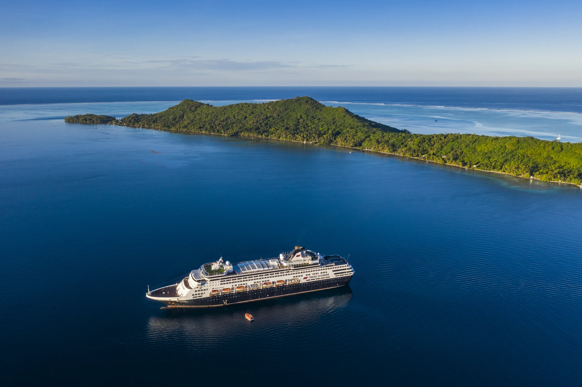 Kreuzfahrtschiff auf Abenteuerreise in tropischen Gewässern.