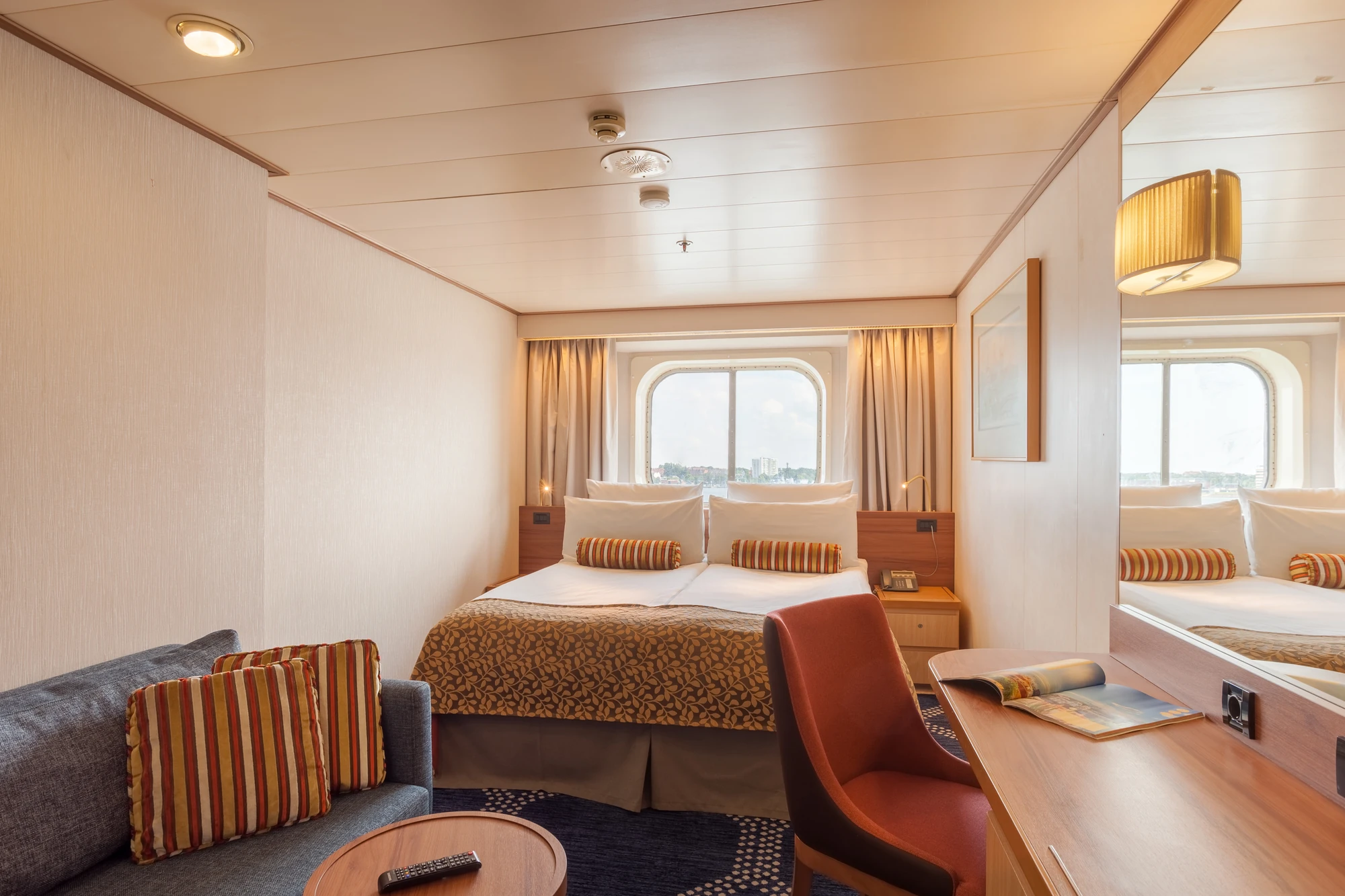 Gemütliche Kabine mit Meerblick auf einem Kreuzfahrtschiff.