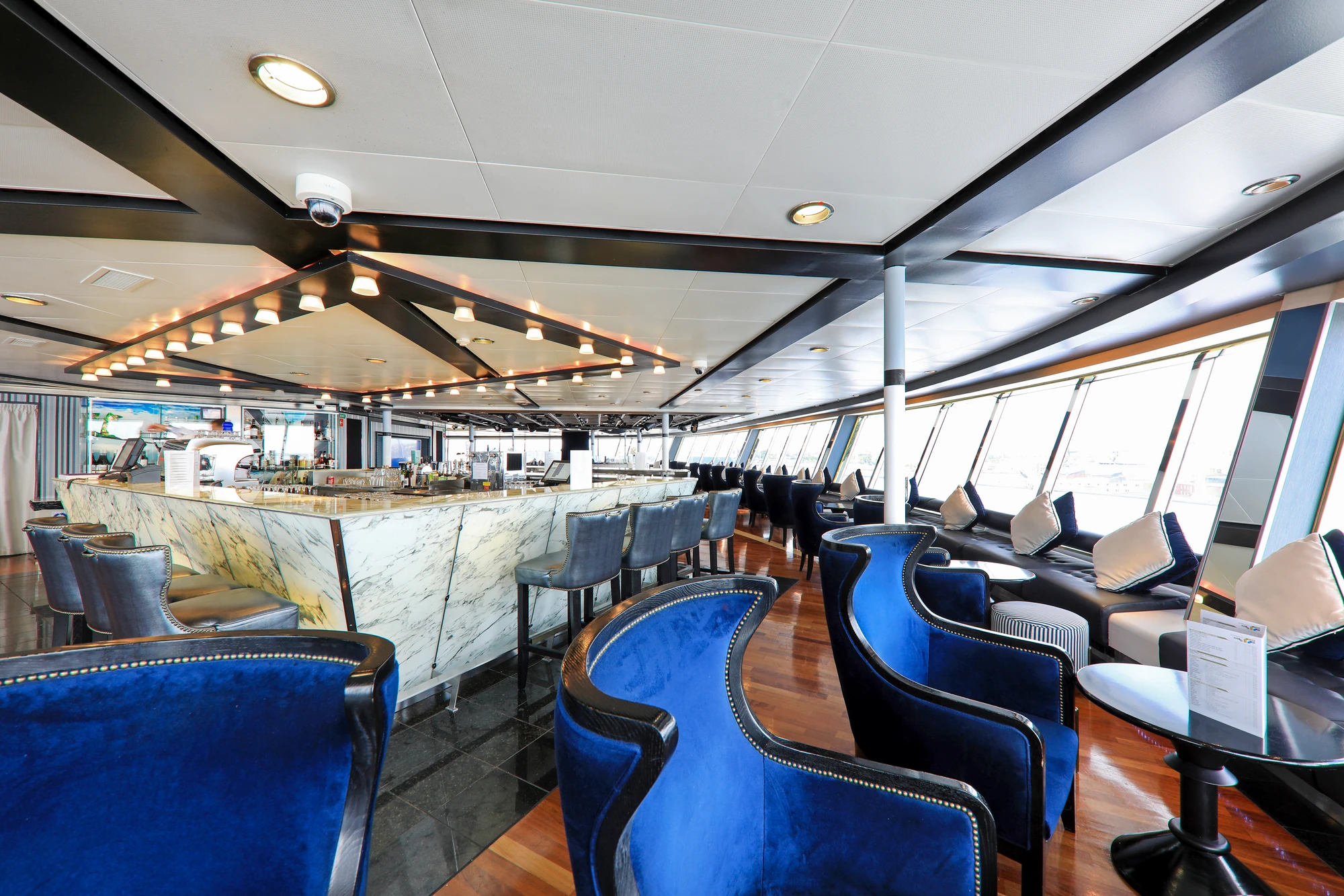 Stilvolle Bar mit blauen Sesseln und Marmor-Theke