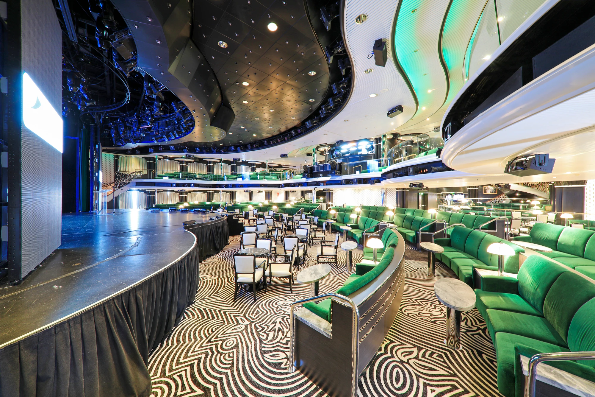 Lounge-Bereich eines Theaters mit komfortablen Stühlen und Tischen.