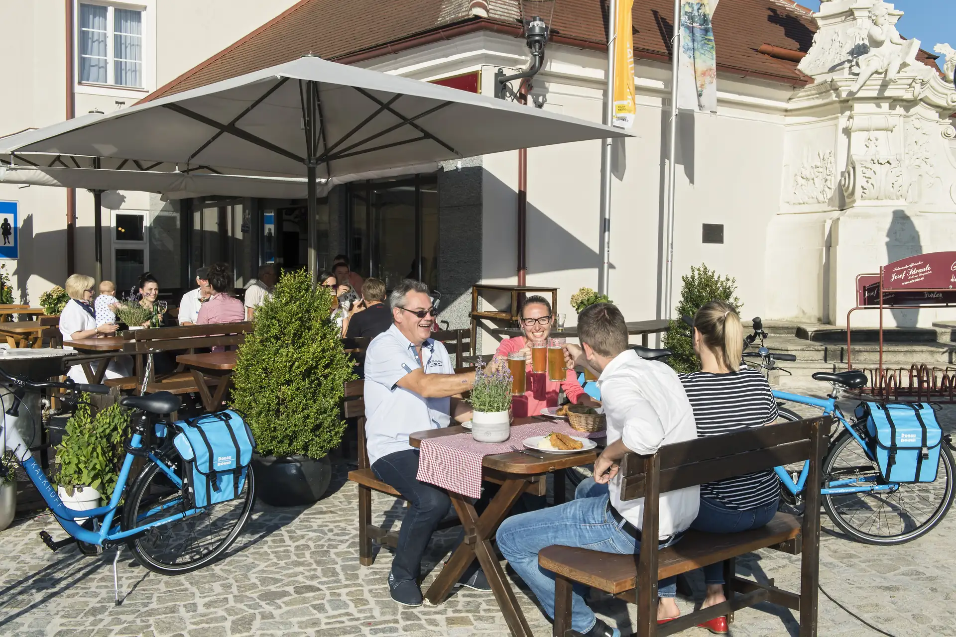 Radler prosten sich bei einer Pause in einer Gaststätte in Melk zu.