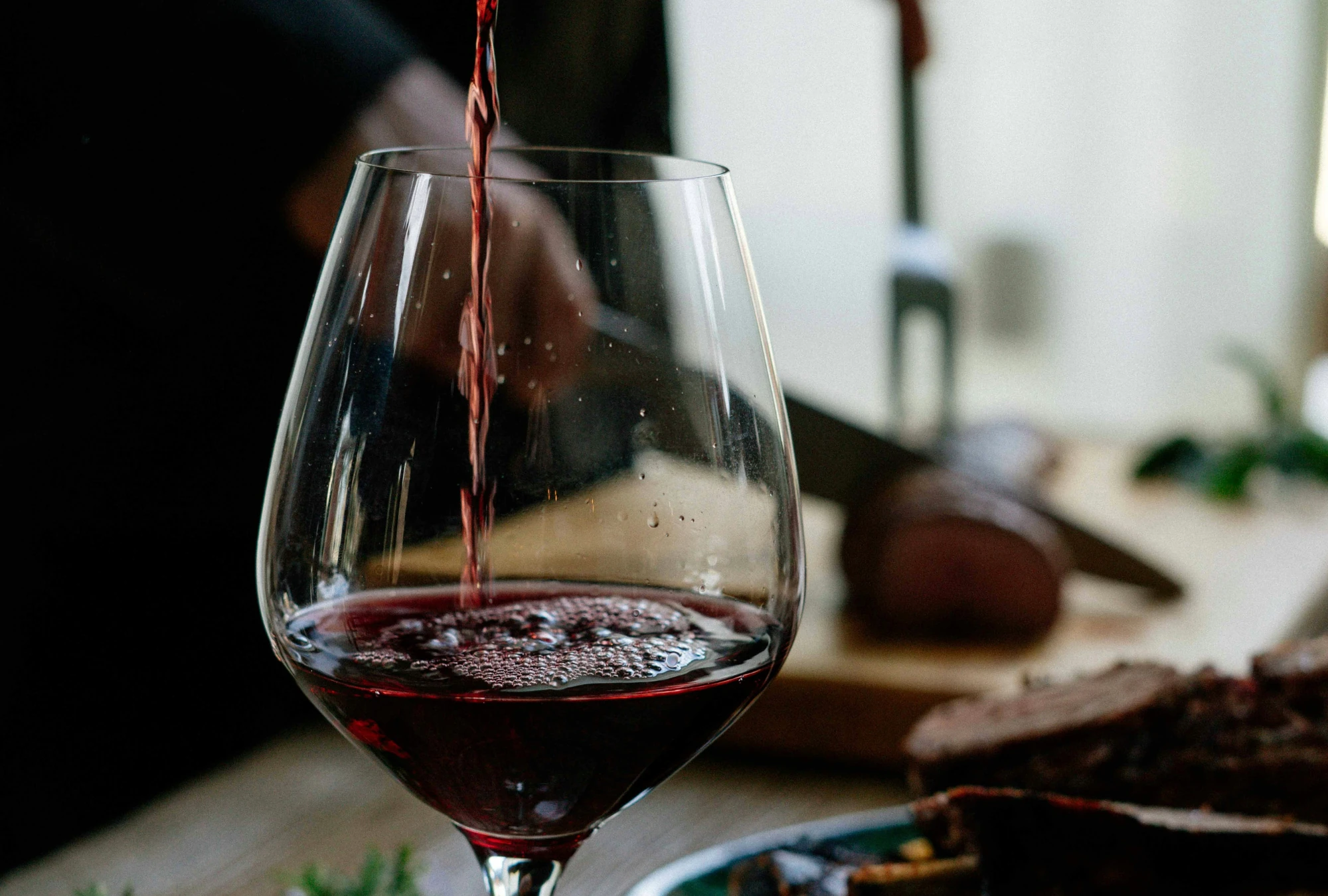 Weinglas in das Rotwein eingeschenkt wird