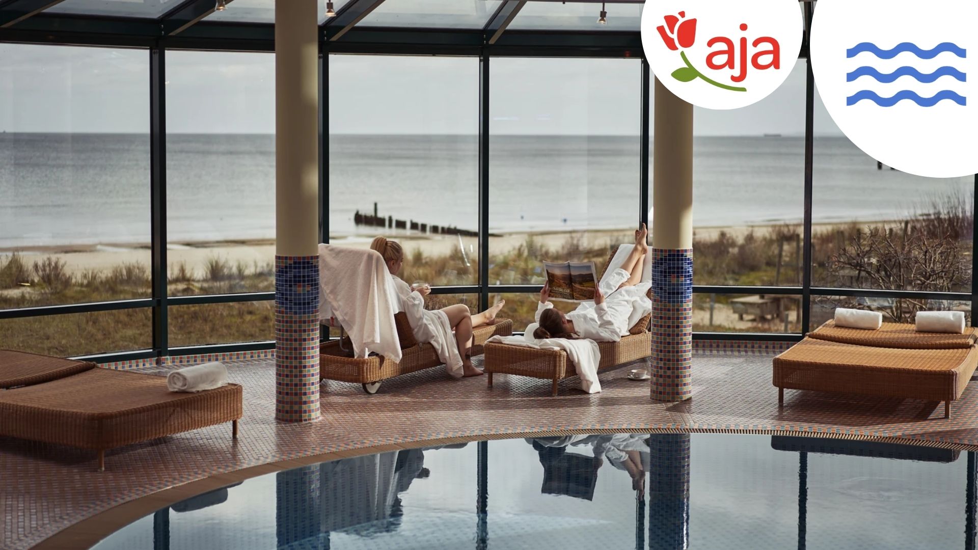 Entspannen mit Meerblick: Im aja Strandhotel Bansin genießen Gäste pure Erholung auf bequemen Liegen im lichtdurchfluteten Wellnessbereich. Der direkte Blick auf die Ostsee und den feinsandigen Strand schafft eine einzigartige Atmosphäre der Ruhe und Gelassenheit. - mit Logo und Wellen-Icon