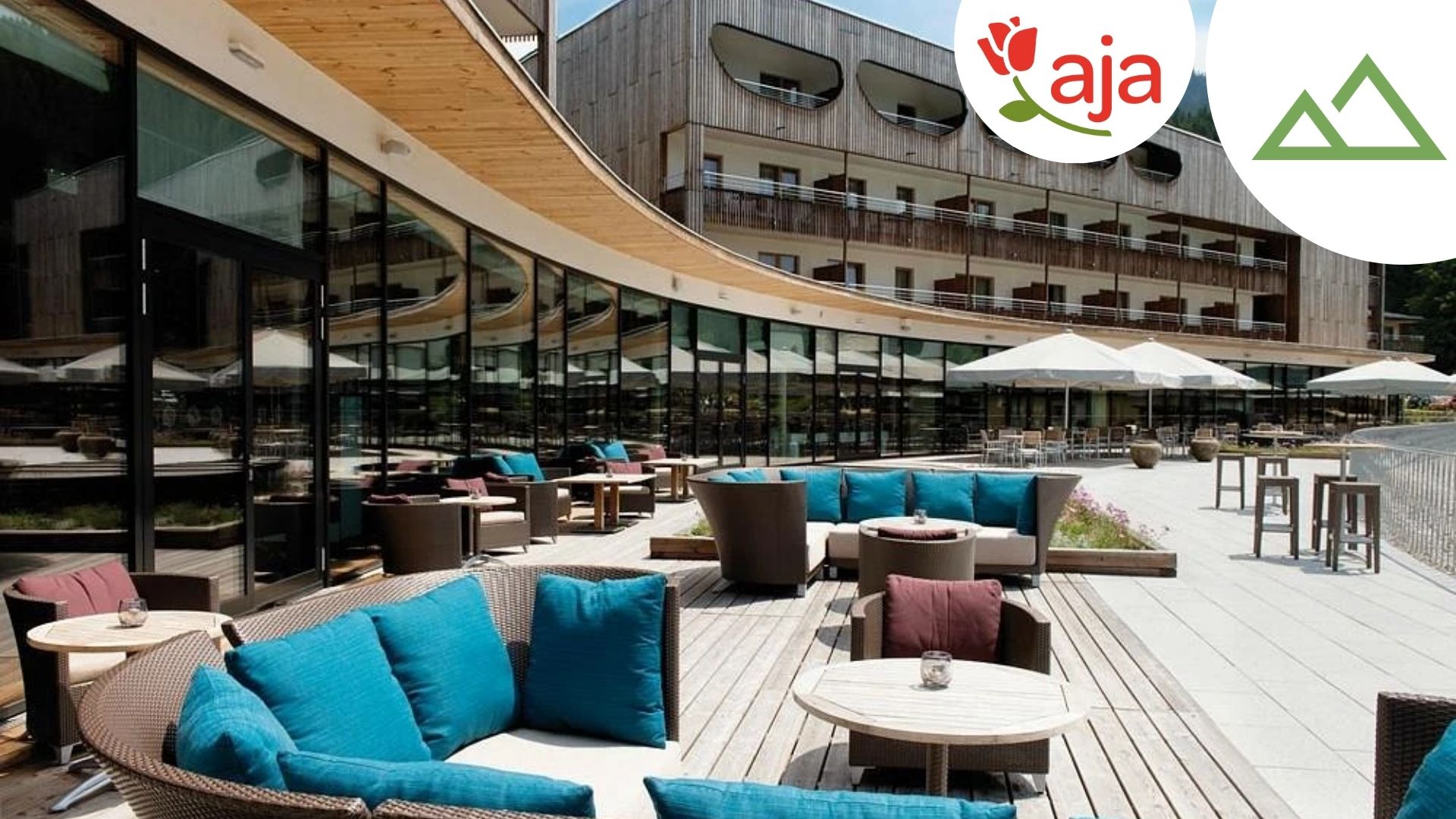 Blick auf den Außenbereich im aja Bergresort Werfenweng mit Bestuhlung- mit Logo & Berge-Icon