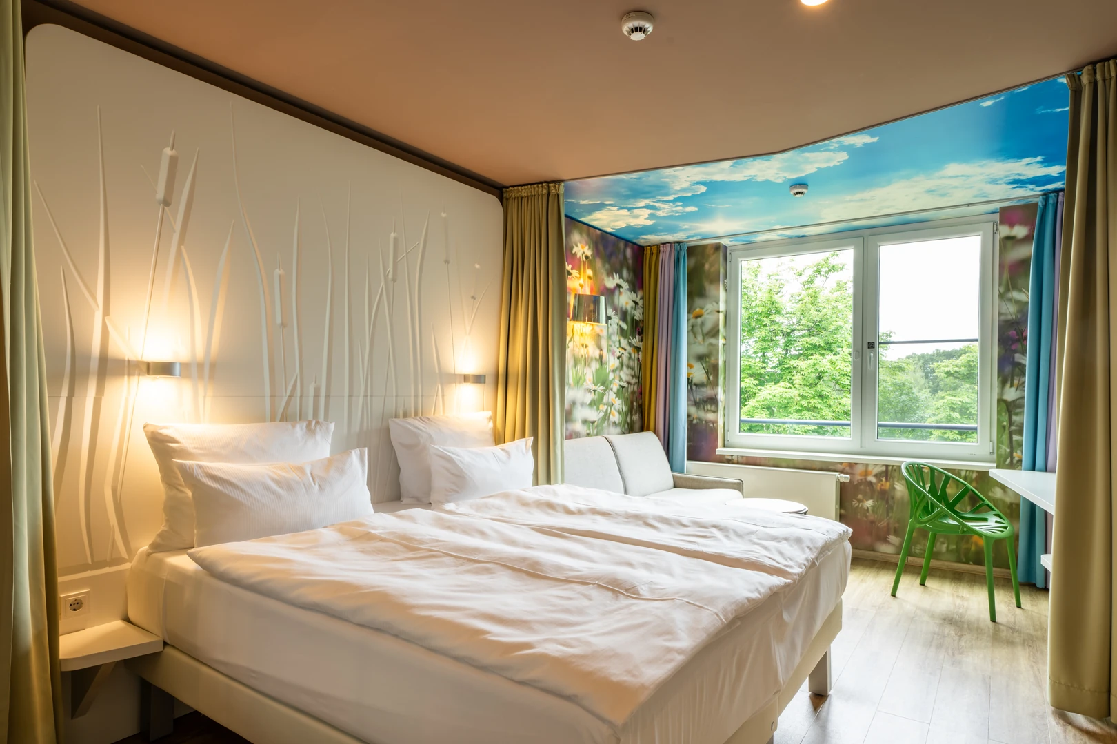 Das modern gestaltete Zimmer im aja Resort Bad Saarow bietet eine helle und freundliche Atmosphäre. Mit natürlichem Dekor und einer großzügigen Glasdusche ist es perfekt für Entspannung und Komfort. Die liebevollen Details und der Ausblick ins Grüne machen den Aufenthalt zu einem besonderen Erlebnis.