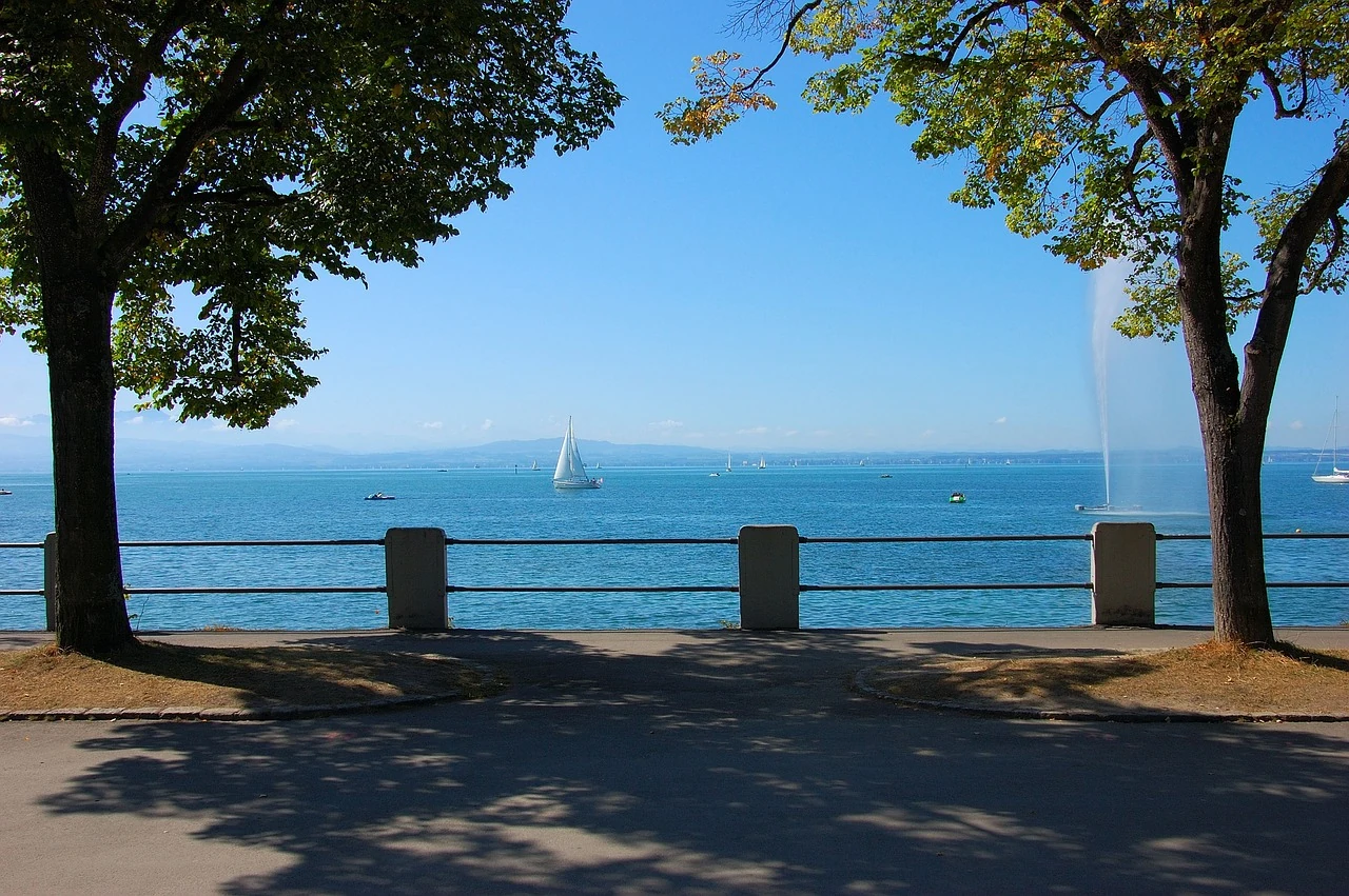 Blick auf den Bodensee mit Segelschiffen von der Uferpromenade
