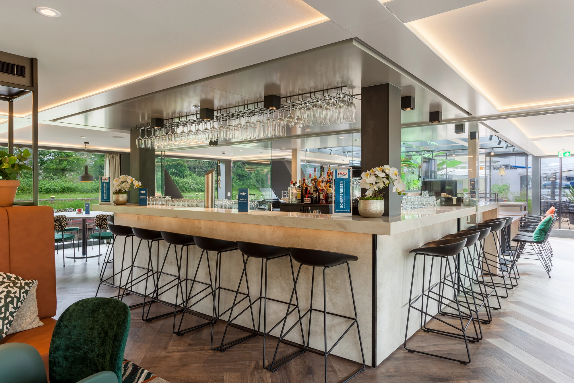 Bar mit Barhockern und Getränken und Blumen an Bord der nickoSPIRIT