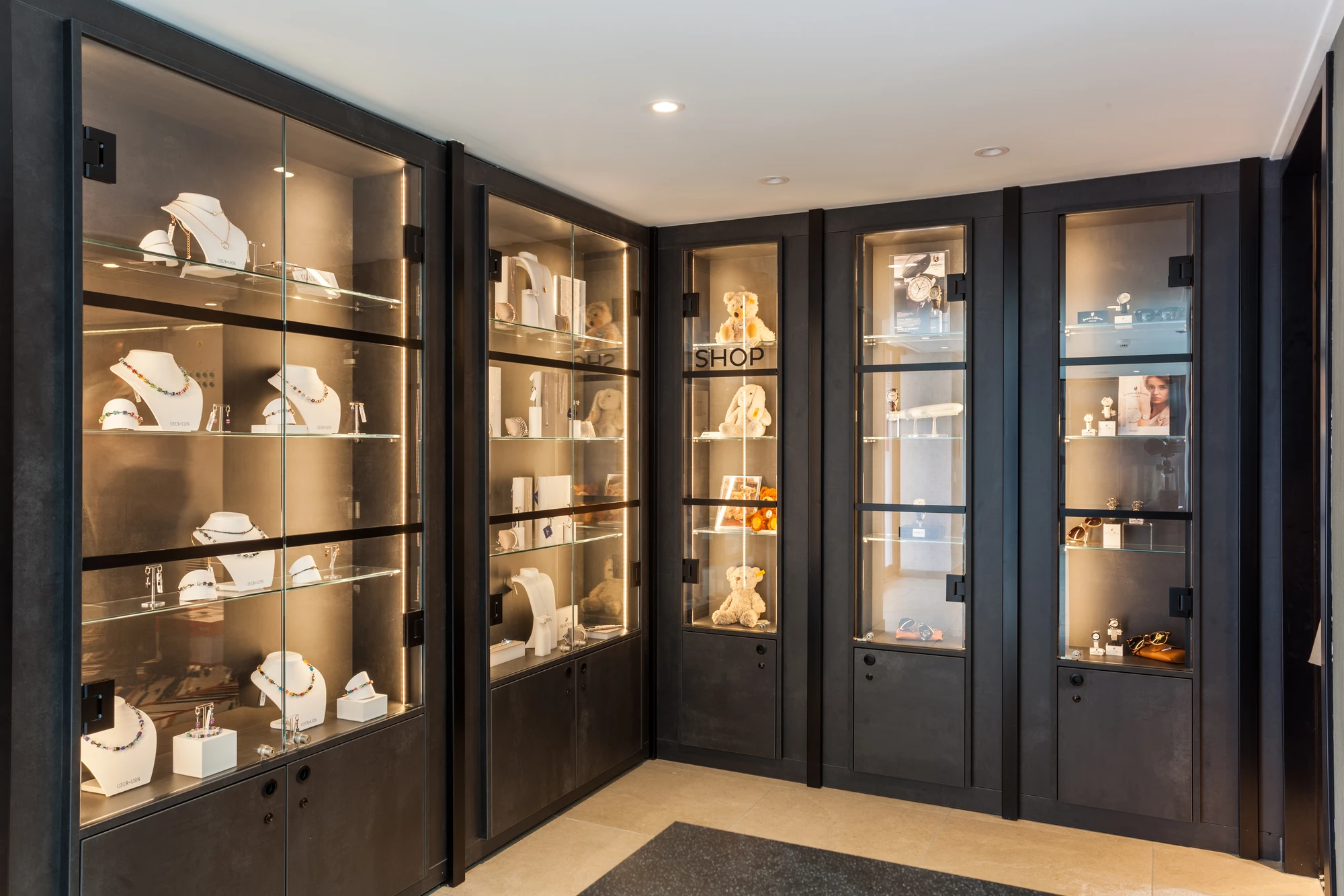 Beleuchtete Regale und verglaste Vitrinen mit Schmuck und Kuscheltieren im Shop an Bord der nickoSPIRIT