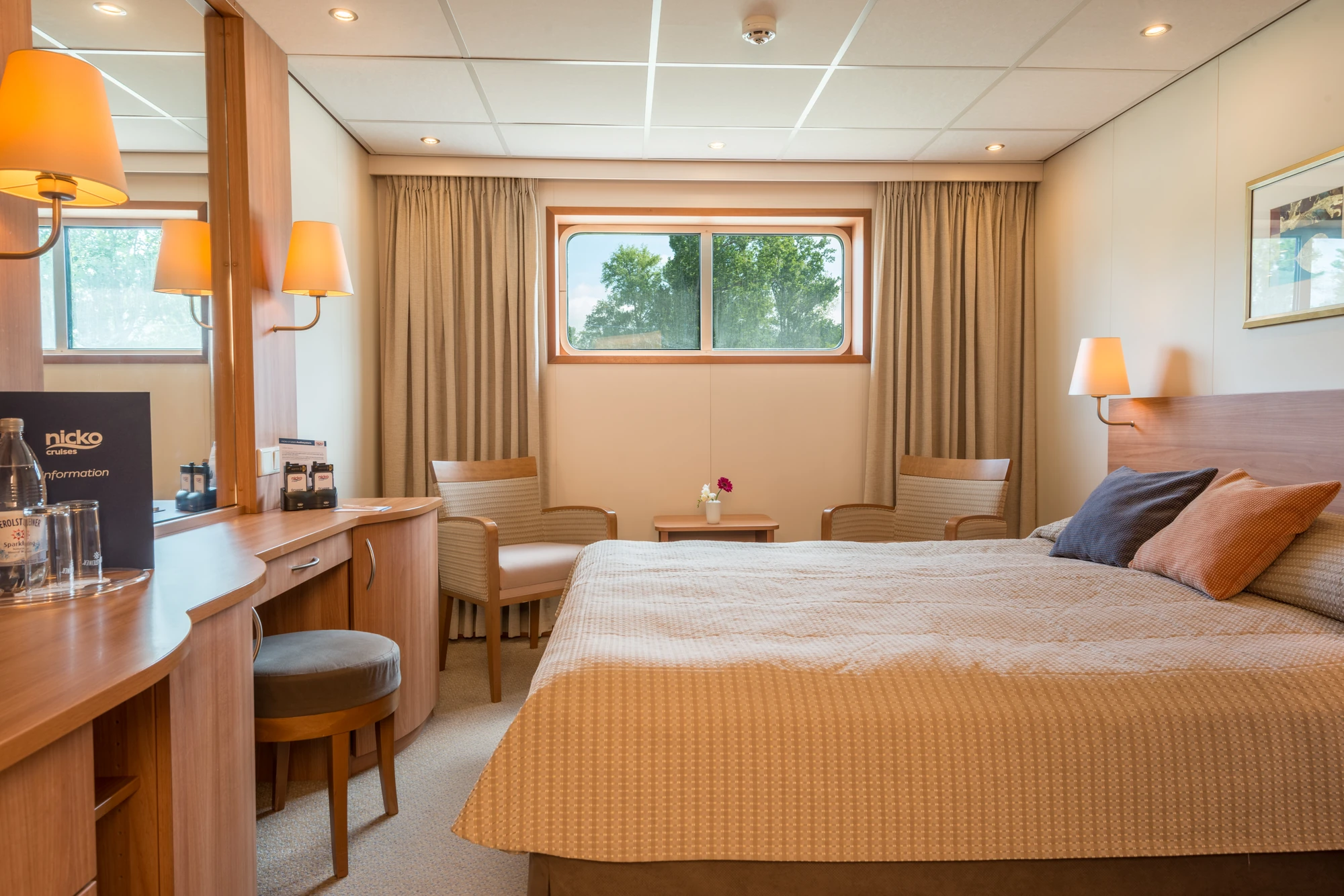 Kabine auf dem Hauptdeck mit einem Doppelbett und Sitzgelegenheit und einem Tisch mit Spiegel mit einem kleinen Fenster