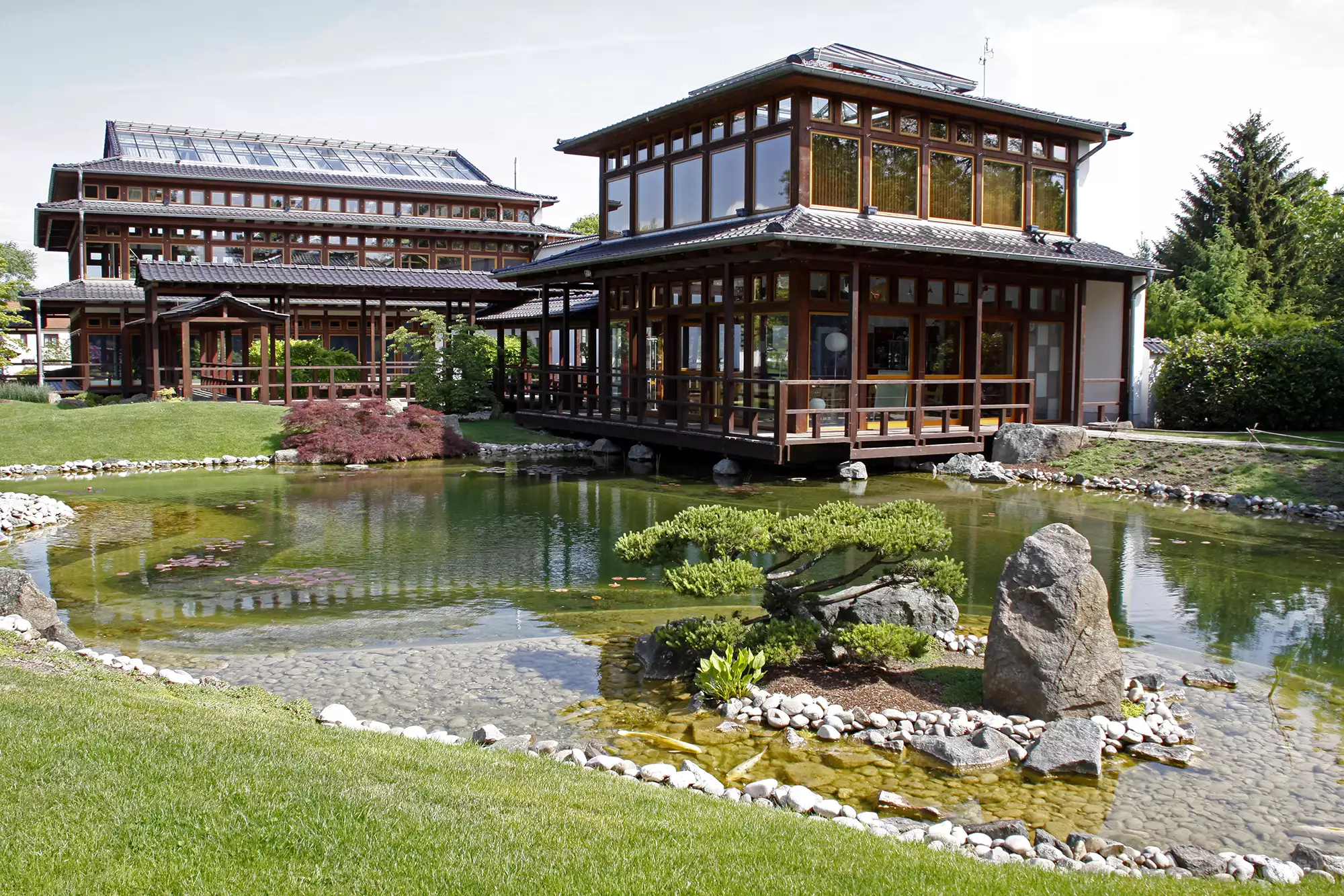 Japanischer Garten mit Steinteich vor zwei Häusern in japanischer Architektur in Bad Langensalza