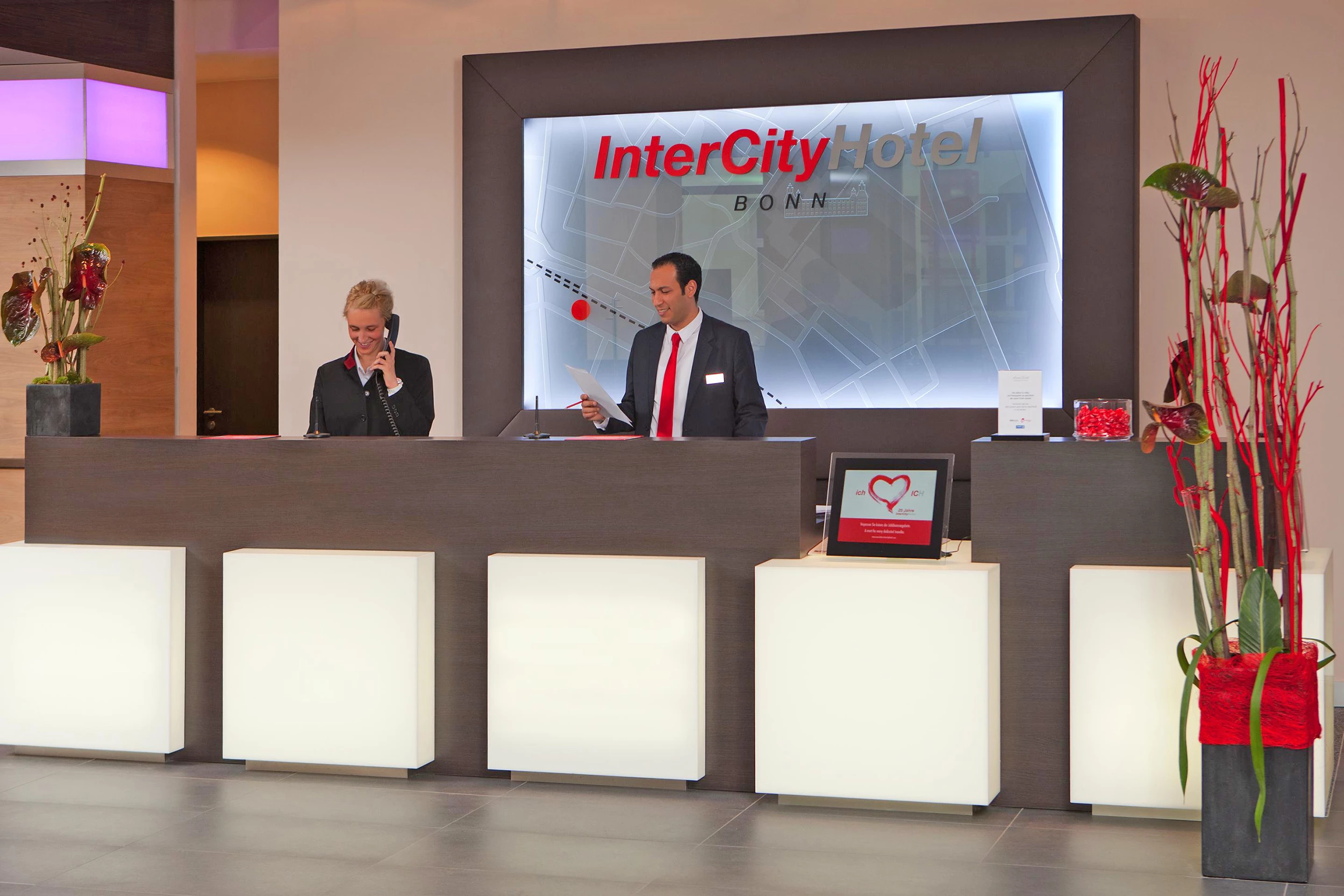 2 freundliche Mitarbeiter am Empfang im IntercityHotel Bonn