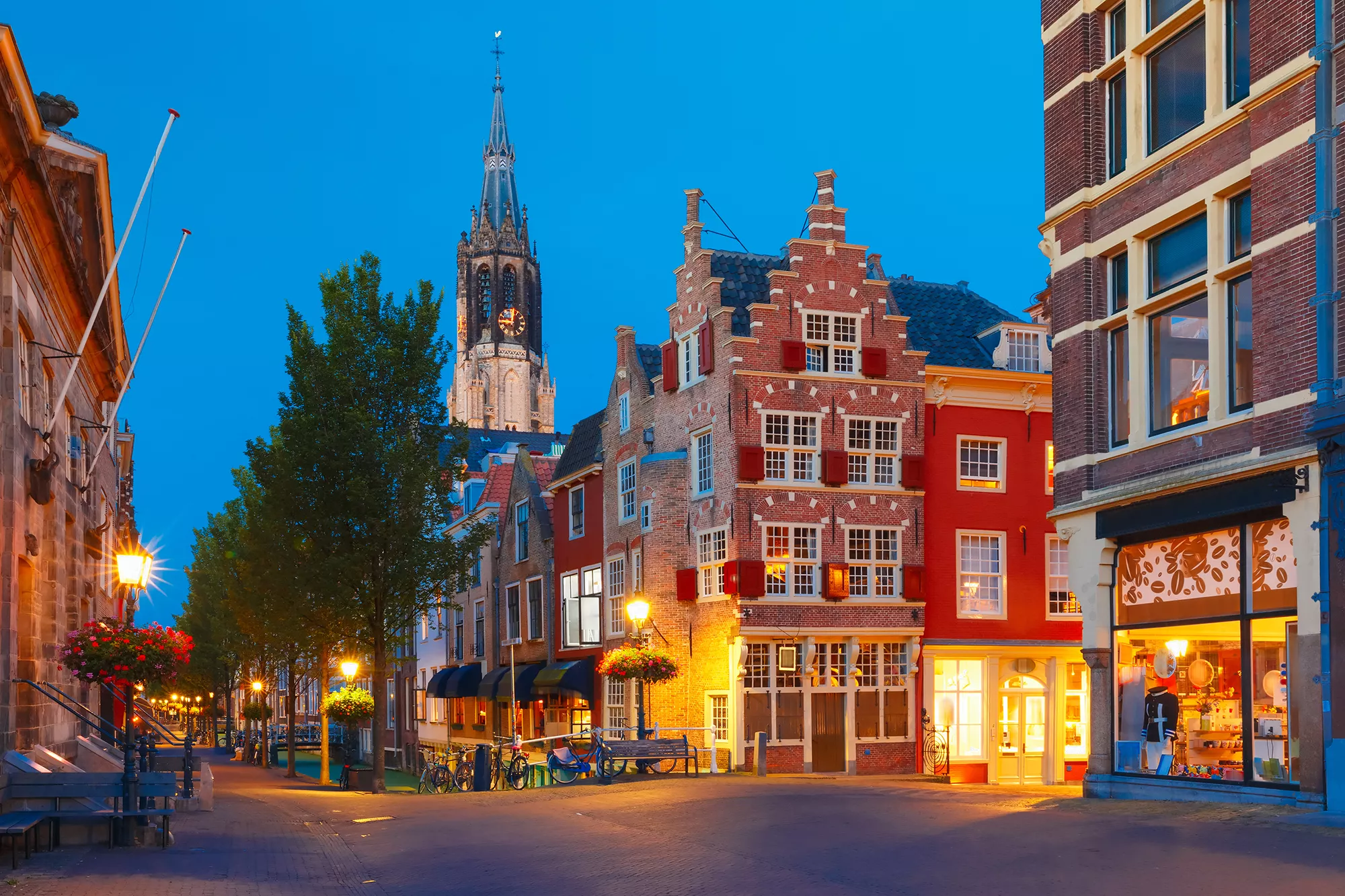 Blick auf die Nieuwe Kerk in Delft während der Abenddämmerung, umgeben von stimmungsvoller Stadtbeleuchtung, die die historische Atmosphäre der Stadt unterstreicht.