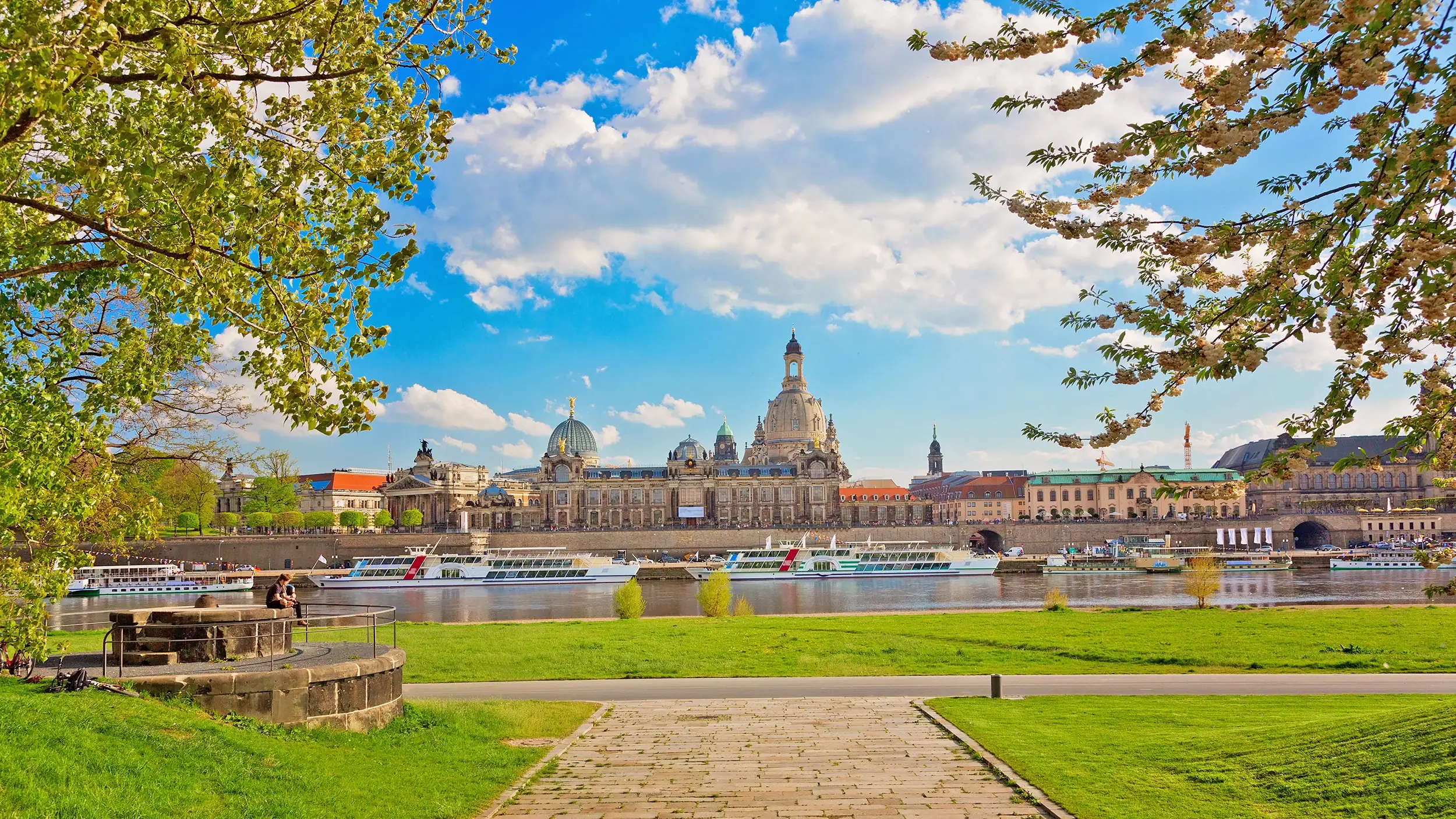 Elbufer bei Sonnenschein im Hintergrund die Kuppel der Semperoper beim Kurzurlaub Dresden