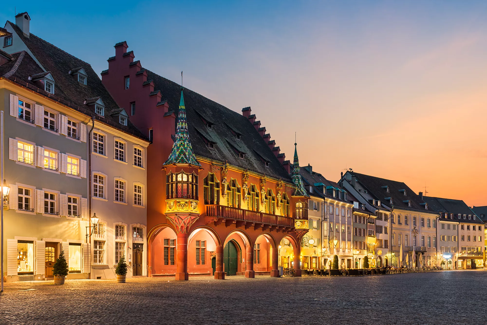 Historisches Kaufhaus bei Nacht auf einer Reie mit Hotel in Freiburg im Breisgau
