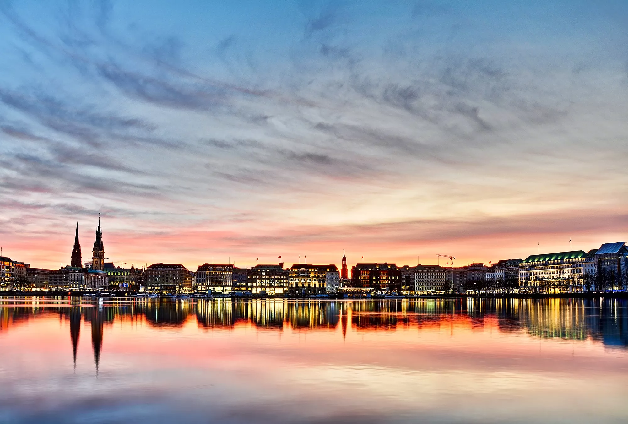 Binnenalster in der Abenddämmerung und Stadtkulisse spiegelt sich in der Alster bei einer Reise Bahn und Hotel Hamburg