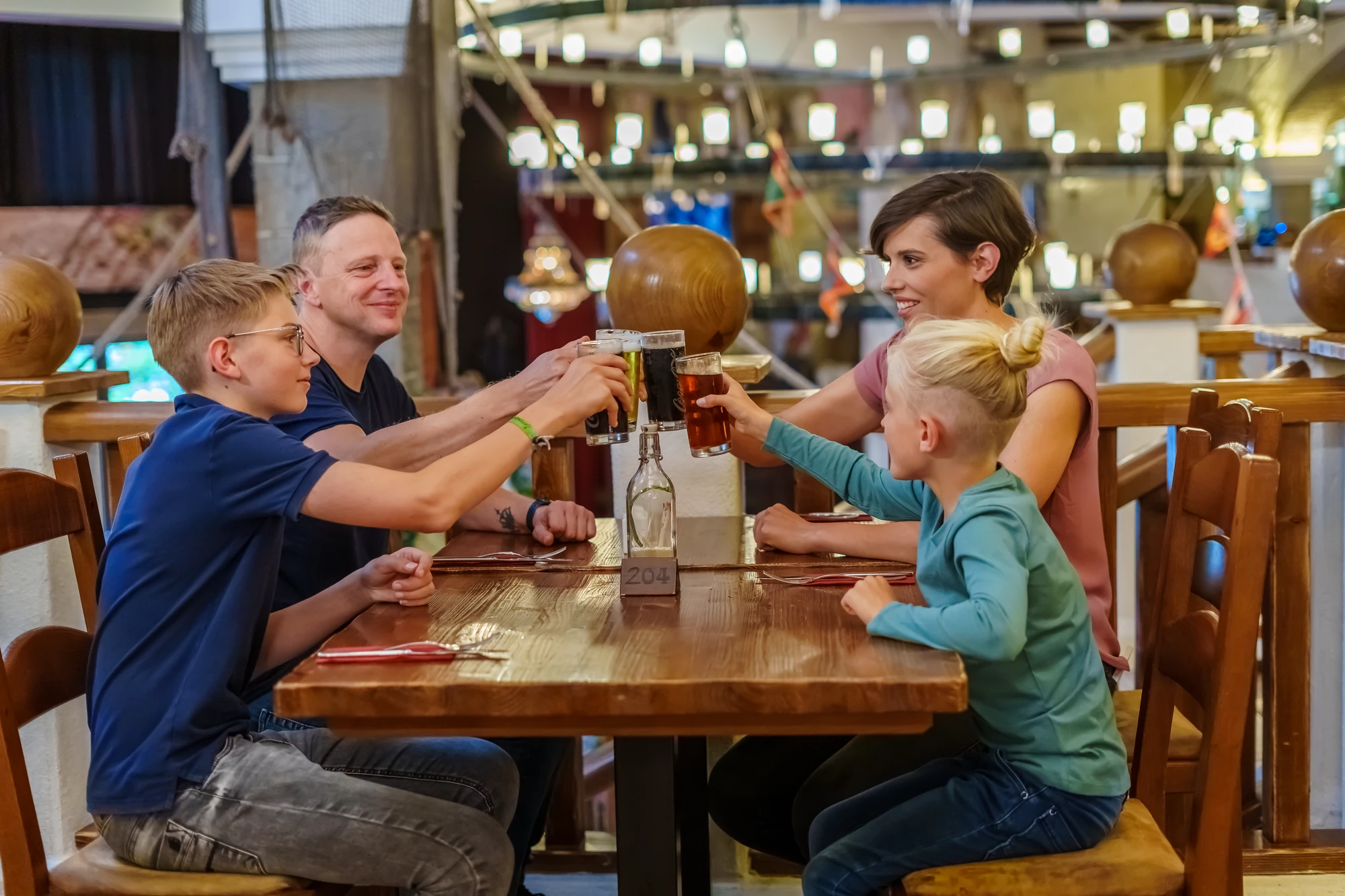 Familie an einem Tisch mit Getränken im Buffetrestaurant im Abenteuerhotel im Heide Park