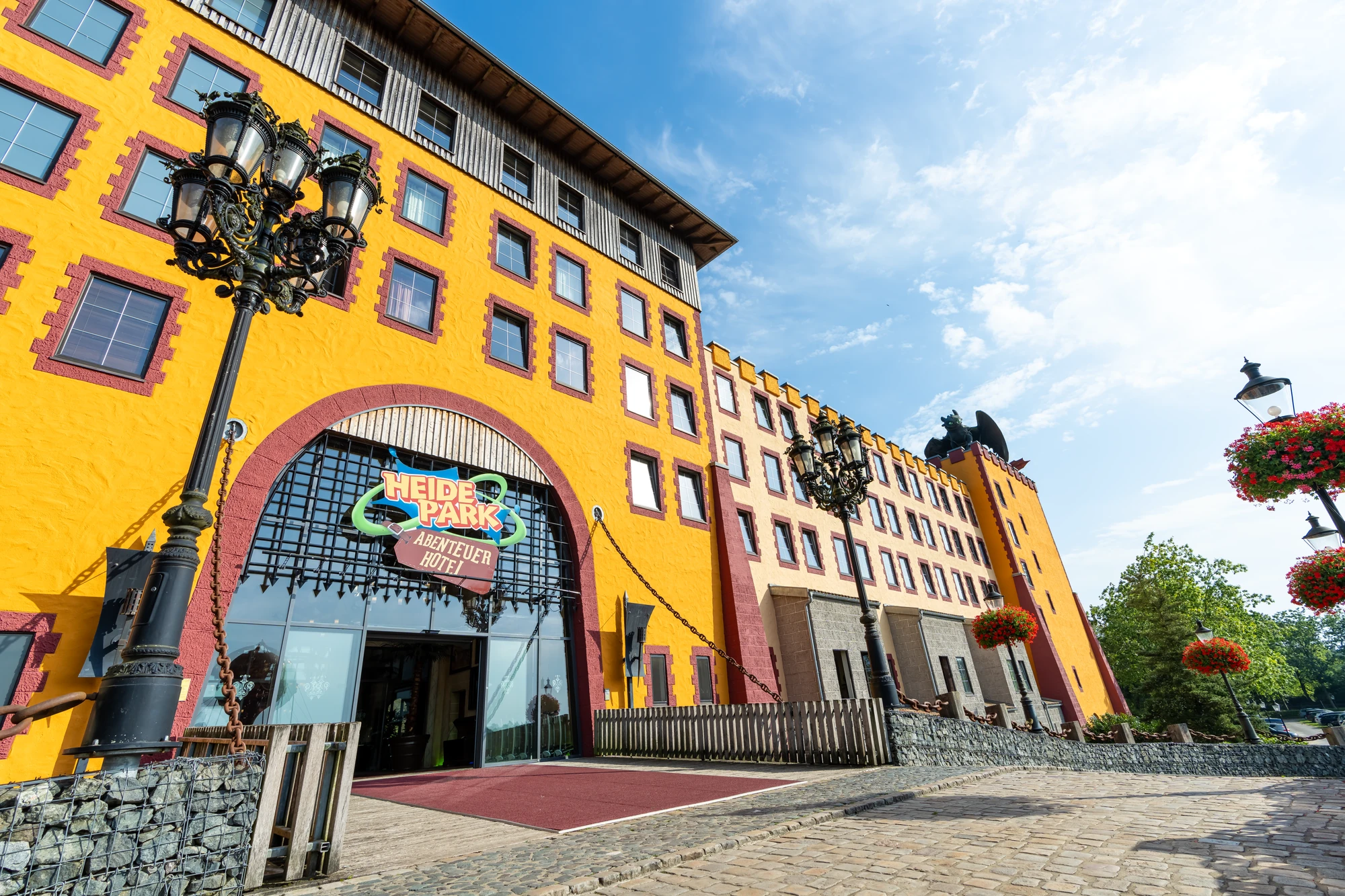 Außenansicht und Eingangsbereich vom gelben Abenteuerhotel im Heide Park