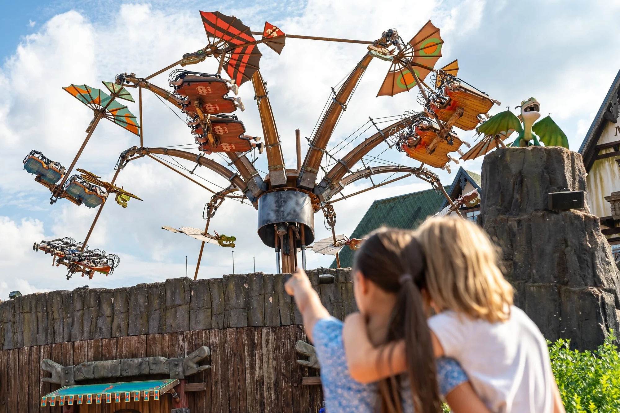 Fahrgeschäft Hicks Himmelsstürmer mit Flugzeugen während der Fahrt in der Luft mit Frau und Kind im Vordergrund