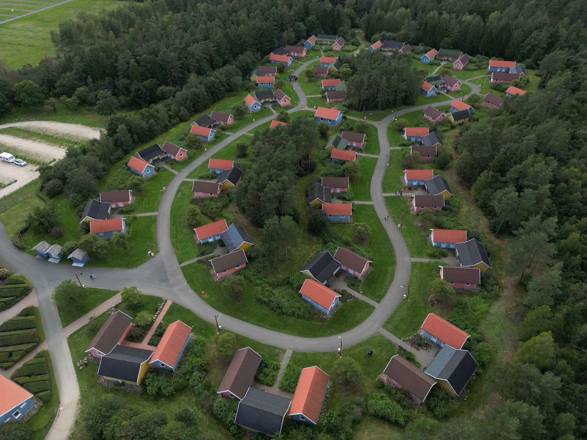 Blick von oben auf die Hütten im Holiday Camp an einer verbindungsstraße mit Bäumen drum herum im Heide Park