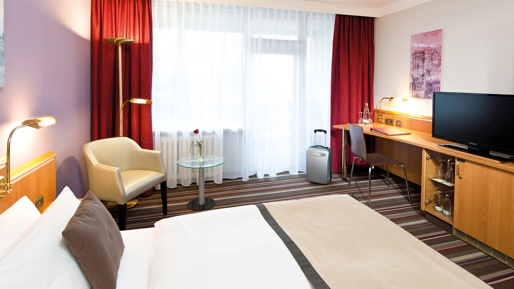 Zimmerbeispiel mit Einzelbett, Sitzgelegenheit, Schreibtisch und Fernseher im Leonardo Hotel Hannover